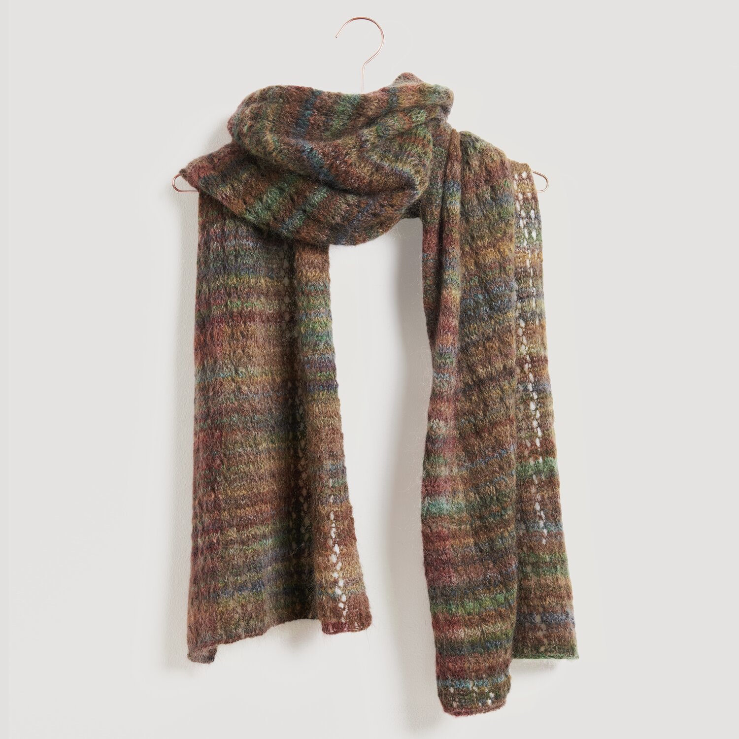 Ein gestrickter Schal in warmen Erdtönen, darunter Braun, Grün und Rot. Der Schal ist von der Marke Modell Legeware und bietet ein stilvolles, gemütliches Accessoire für kühle Tage.