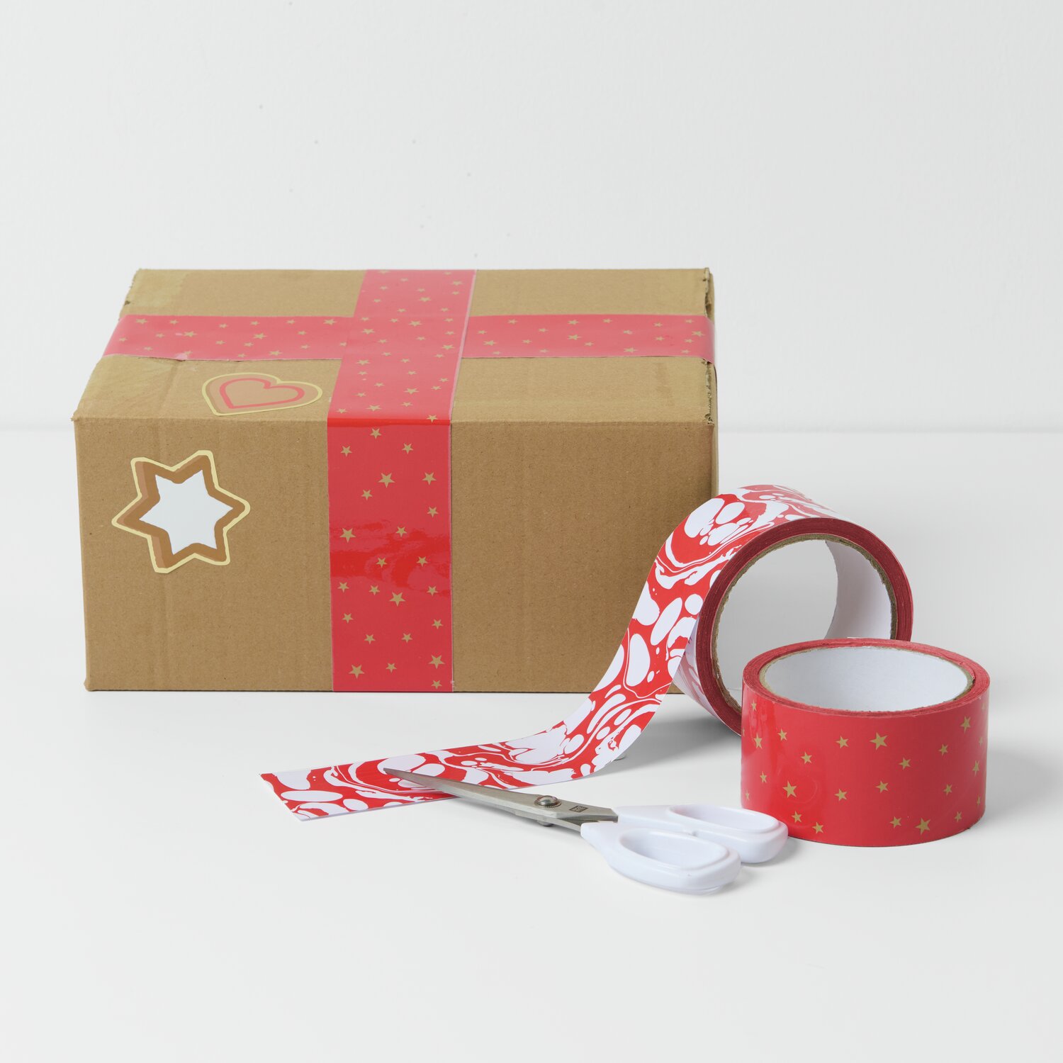 Paketklebeband Marmoriert Rot/Weiß 5cm 33m von Rico Design Paketklebeband Weihnachtsmarkt 5cm, rot-weiß marmoriert, dekoriert ein Paket mit Sternenmotiv. Ideal für festliche Verpackungen.