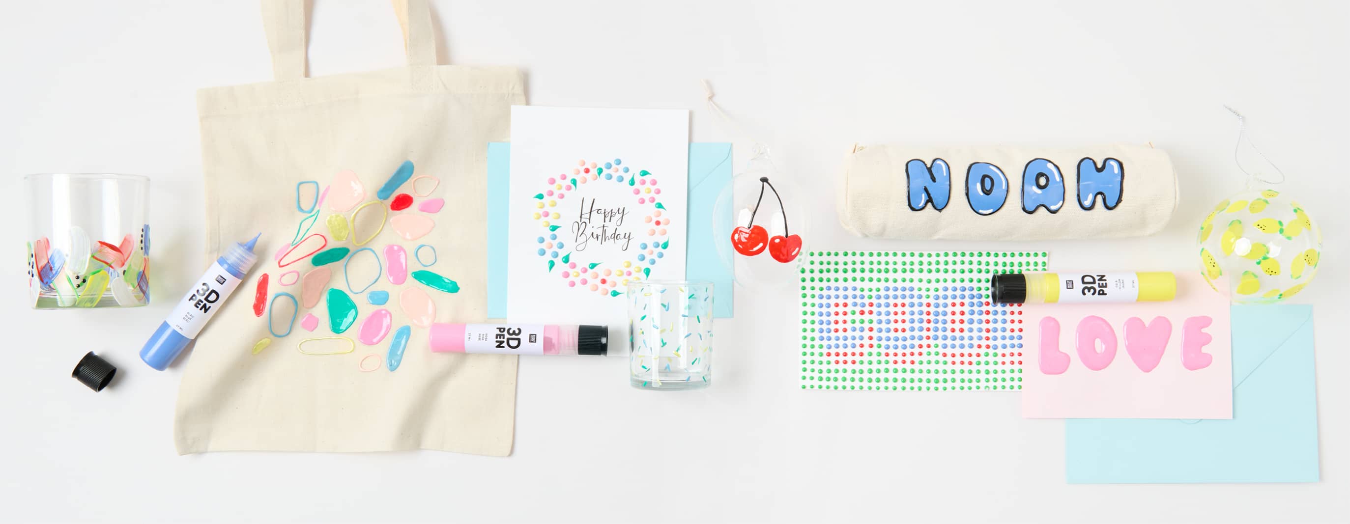 Bunt bemalte Karten, Taschen, Gläser und weitere Produkte mit 3D- und Perlen-Effekten, liegen umgeben von bunten 3D-Pens auf grauem Hintergrund.