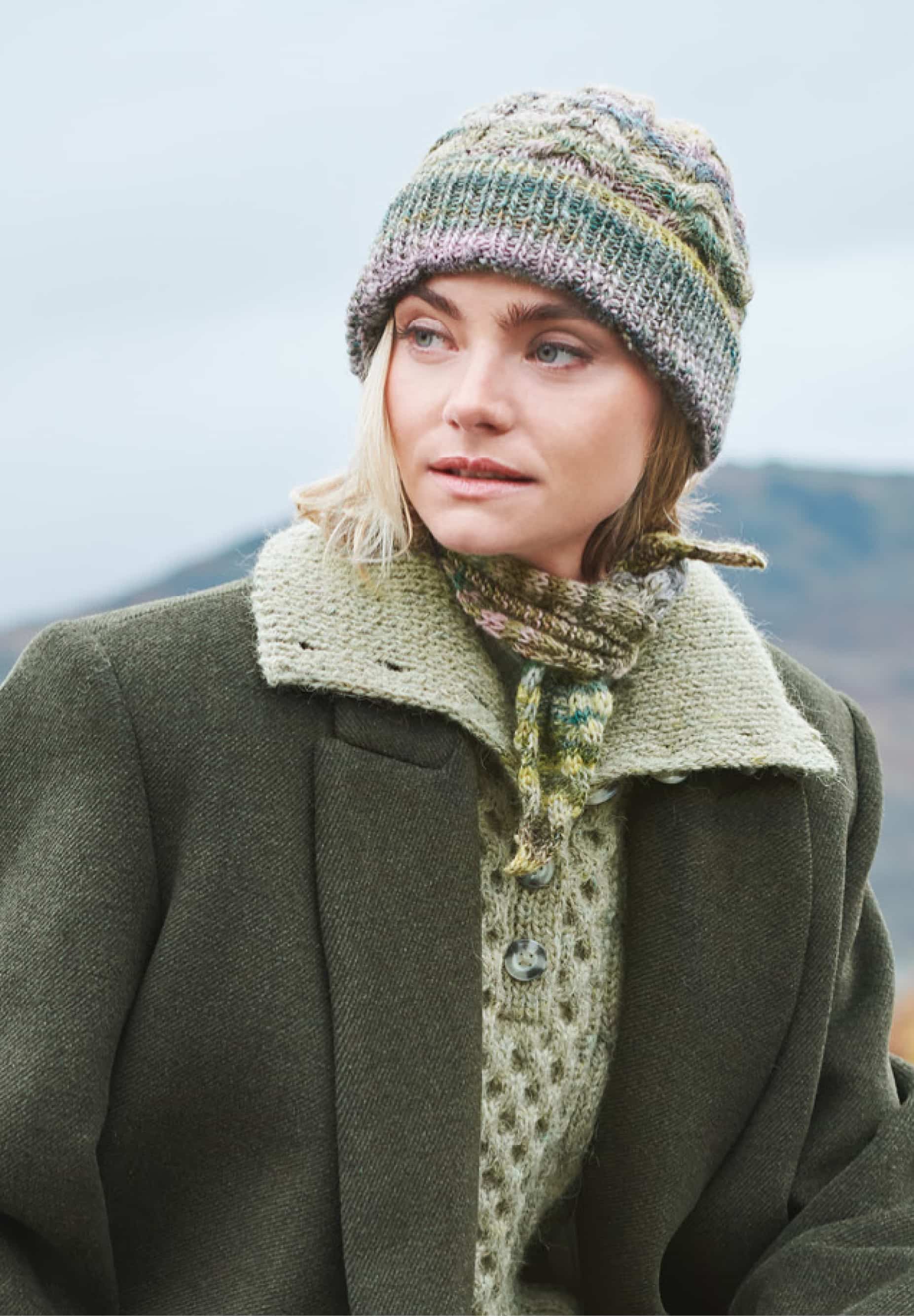 Frau trägt gestrickte Mütze mit Zopfmuster in Grüntönen: Modell 07 aus Lovewool No. 23