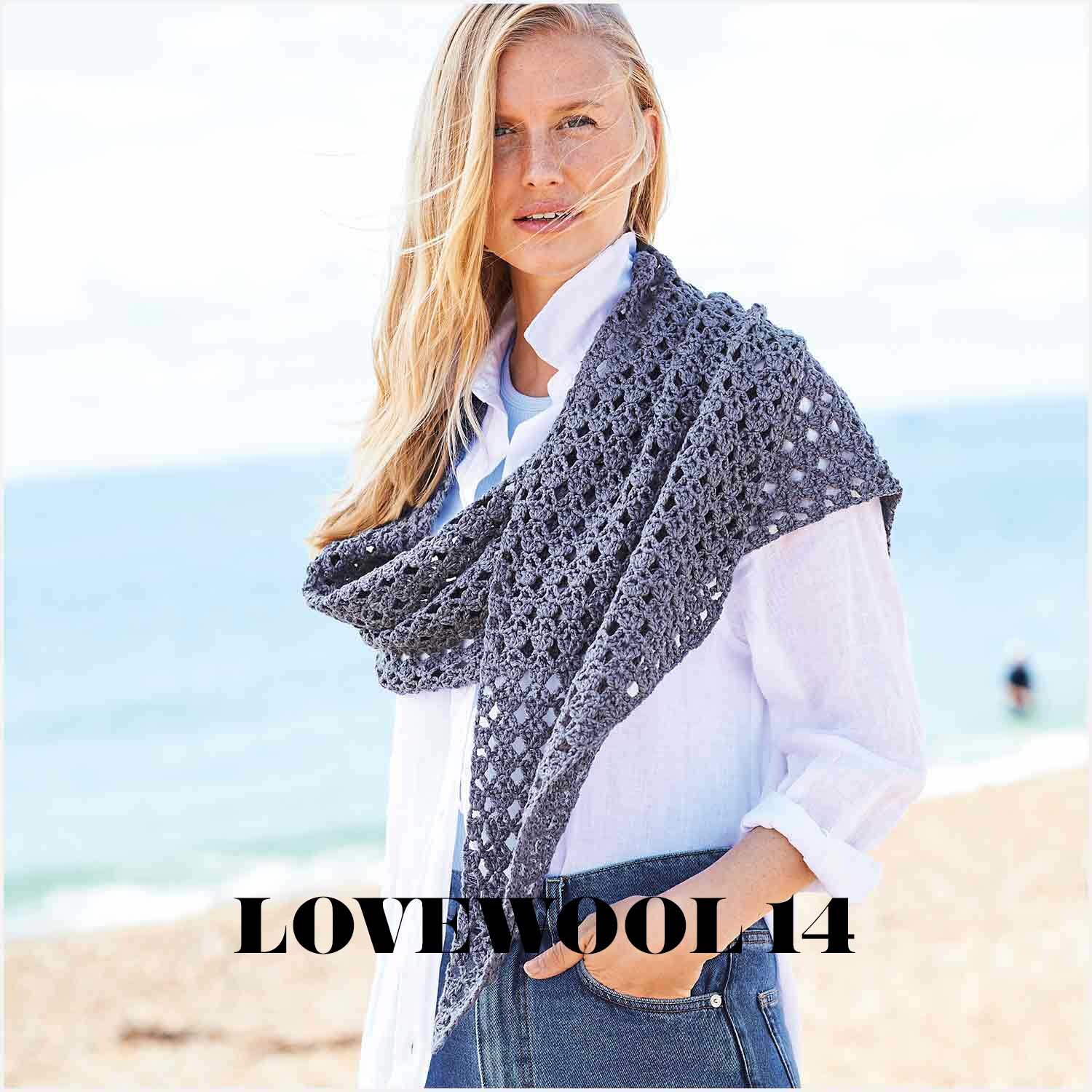 Fashion Silk Blend dk: Frau am Strand mit gehäkeltem Schal in Marineblau, ideal für kühle Tage.