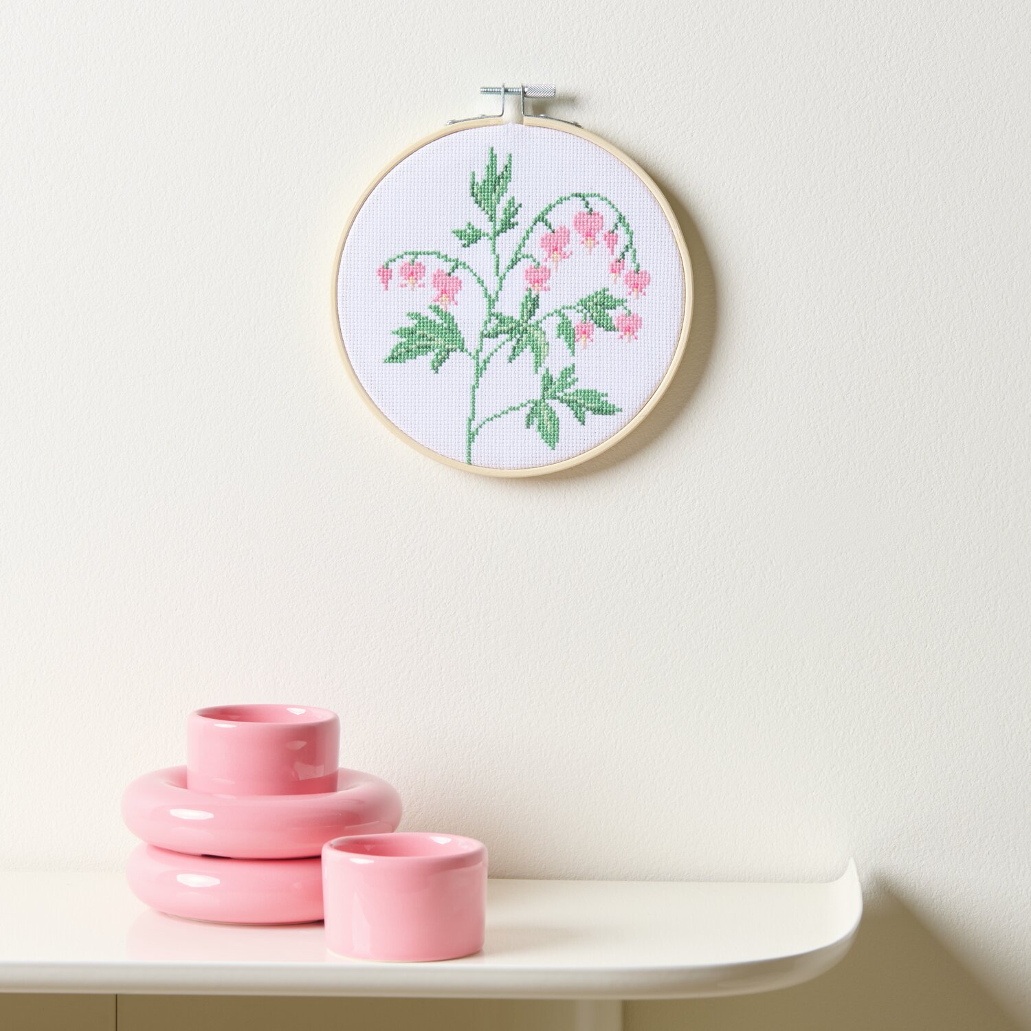 Stickpackung Gezählter Kreuzstich Tränendes Herz zeigt ein florales Design in Rosa und Grün, gerahmt in einem Ø15cm Holzring.
