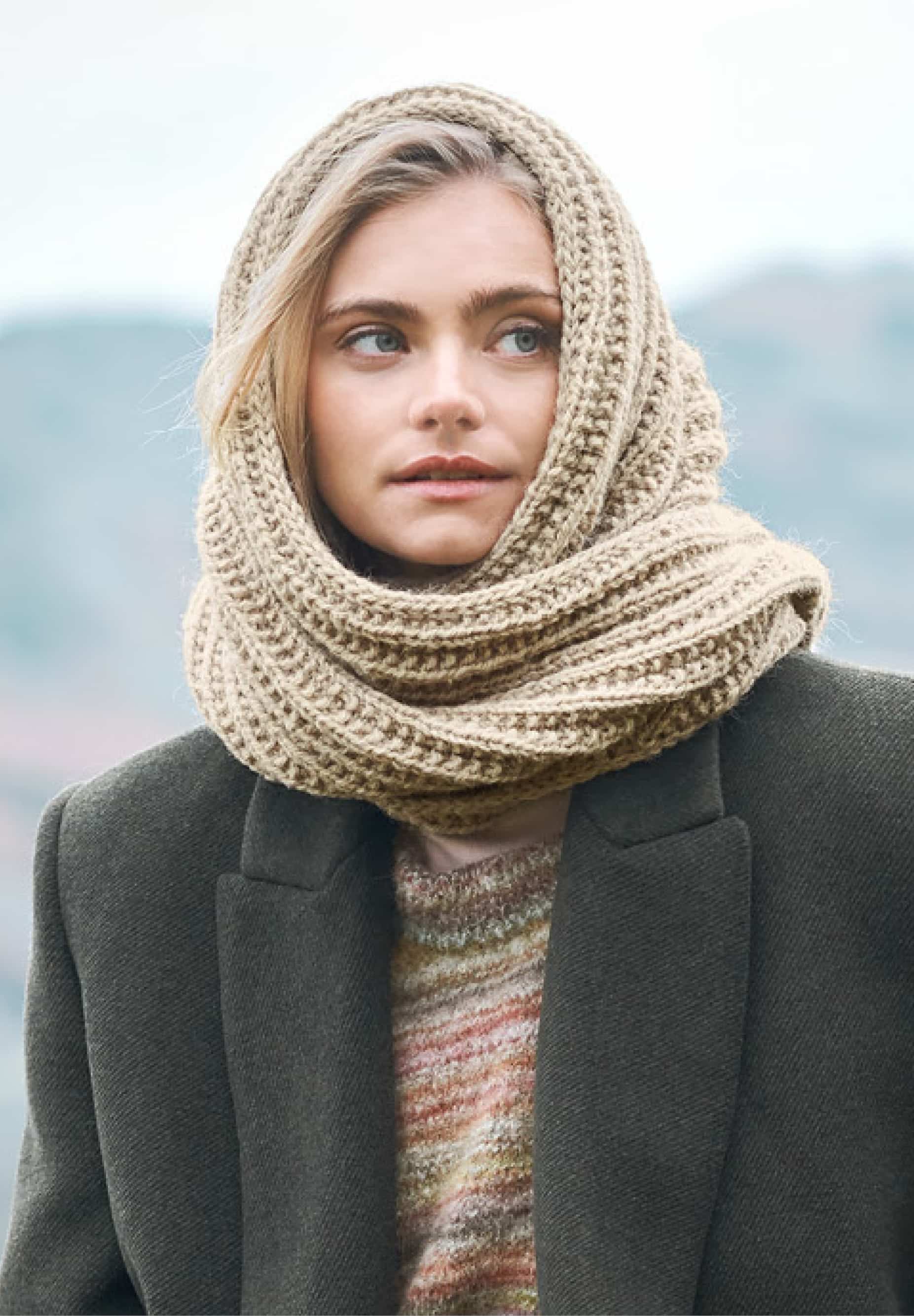 Frau trägt gestricktes Kapuzentuch in Beige: Modell 05 aus Lovewool No. 23