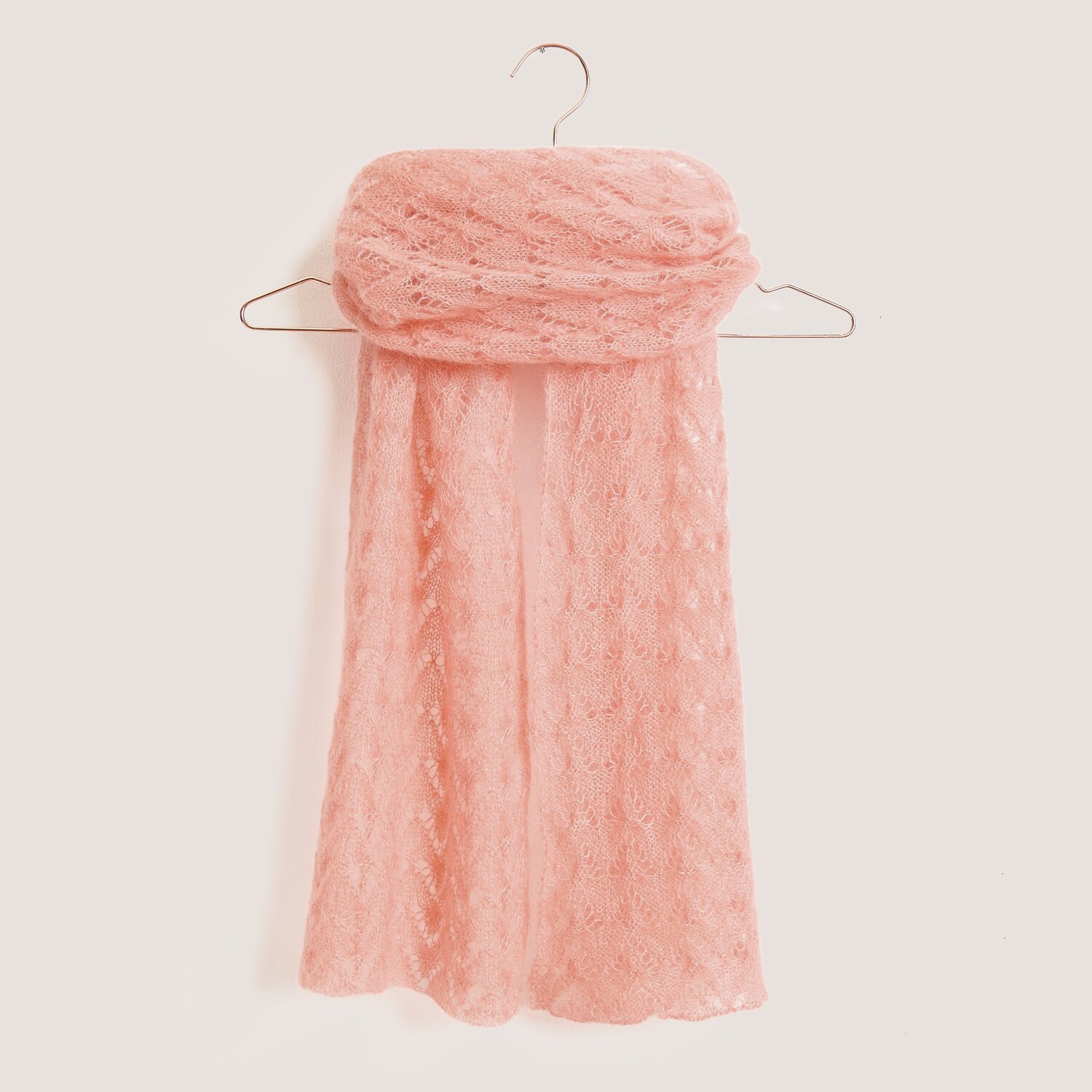 Strickset Tuch Modell 05 aus Tücher Special in Sanddorn auf einem Kleiderbügel. Weiches, leichtes Material von Rico Design.