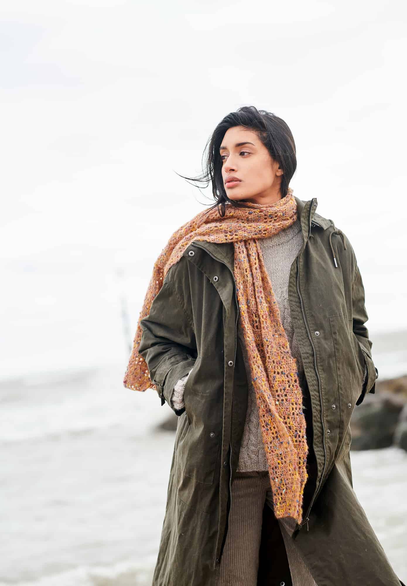 Frau trägt gehäkelten Schal in Orangetönen: Modell 23 aus Lovewool No. 21