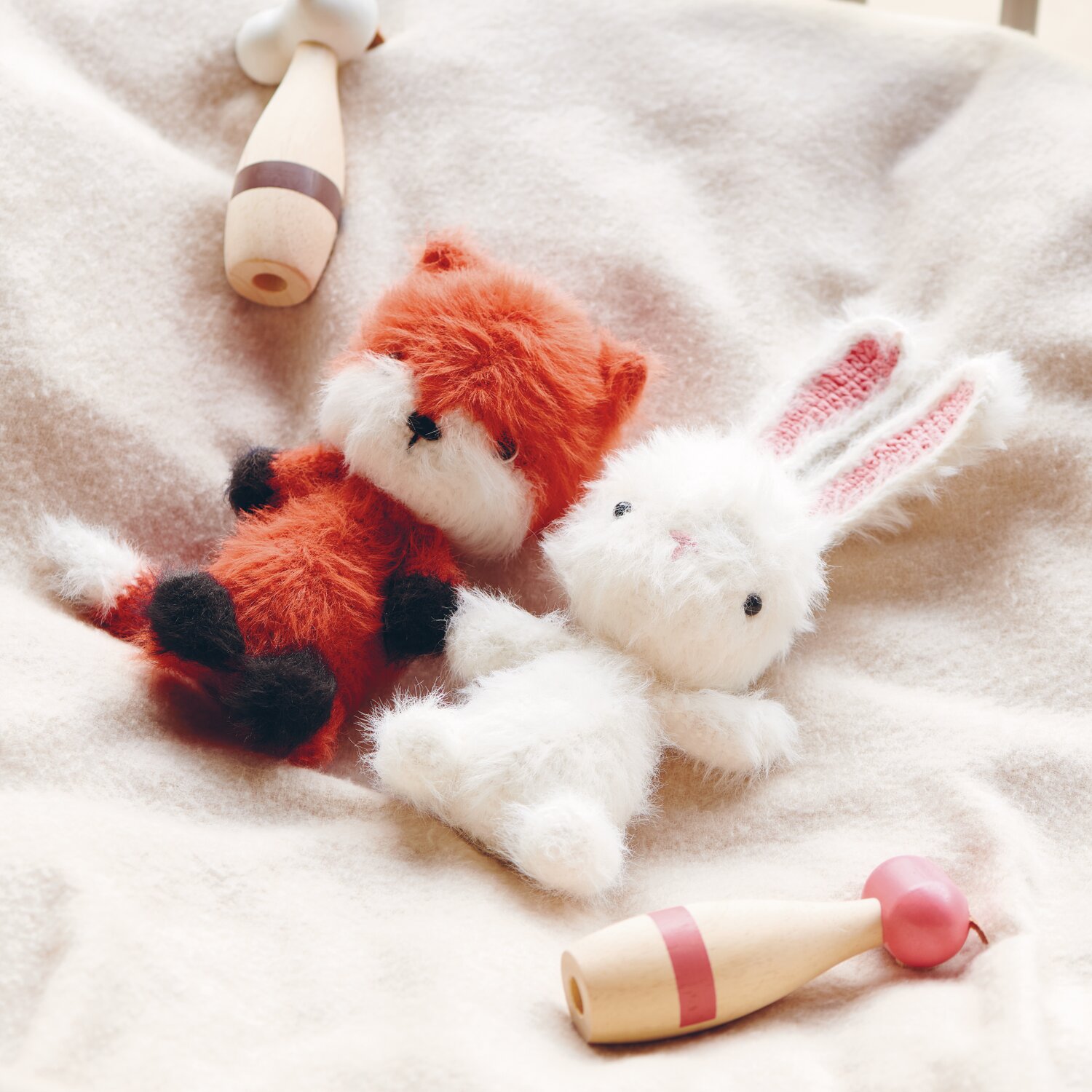 Ricorumi Furry Animals: Zwei weiche Plüschtiere, ein Fuchs in Koralle und ein weißer Hase, auf cremefarbenem Stoff.