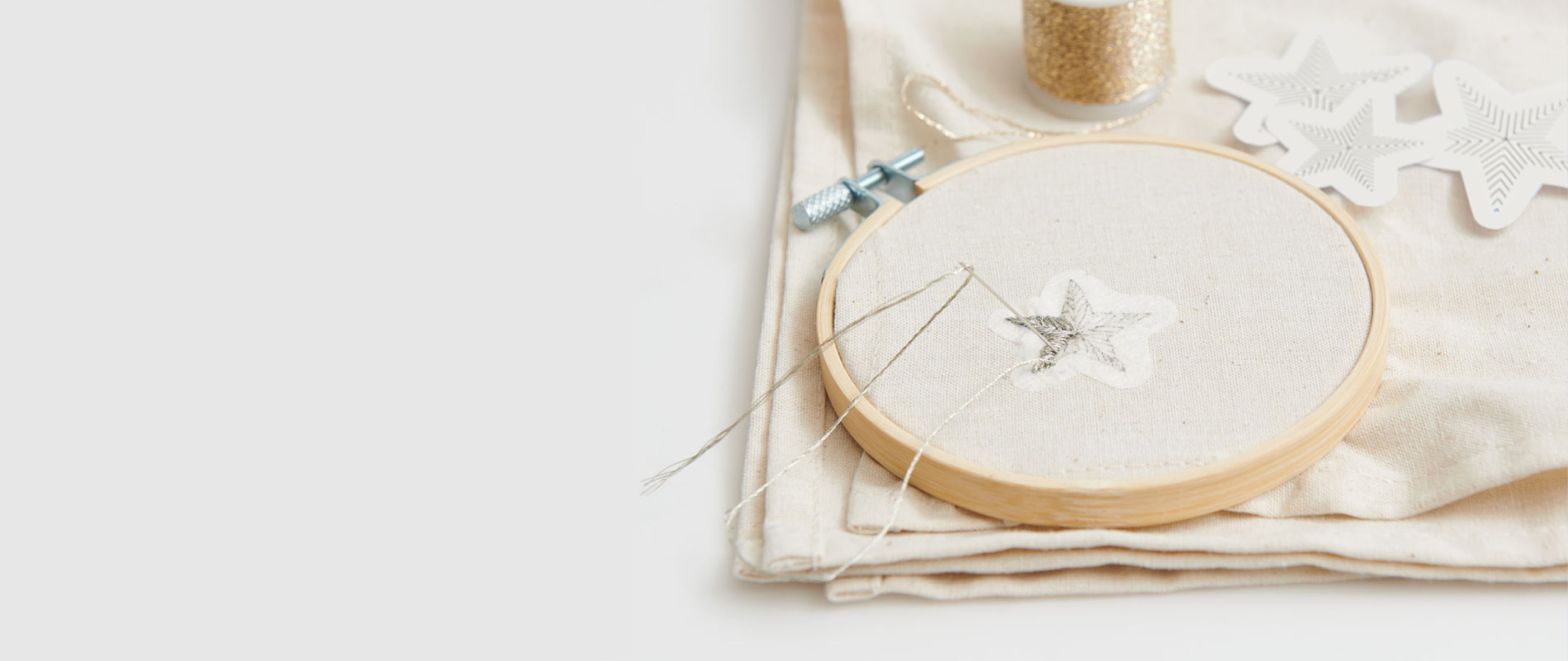 Ein Stick & Stitch-Aufkleber in Sternform klebt auf einem Stoff und wird bestickt.