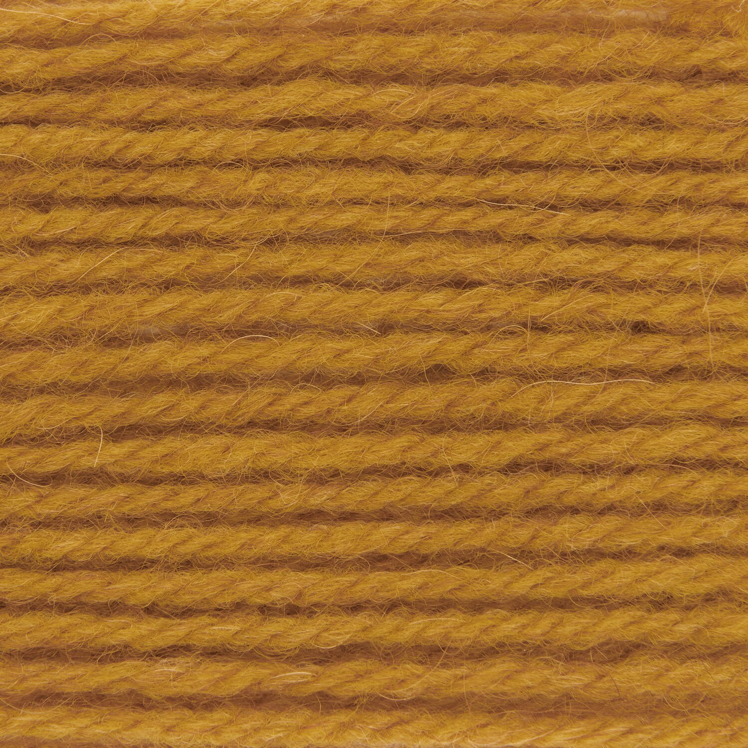 Soft Alpaca, Rico Design, 50g 125m, Nahaufnahme mehrlagiges Garn in warmem Senfton, weiche strukturierte Wolle für Strick- und Häkelprojekte sichtbar