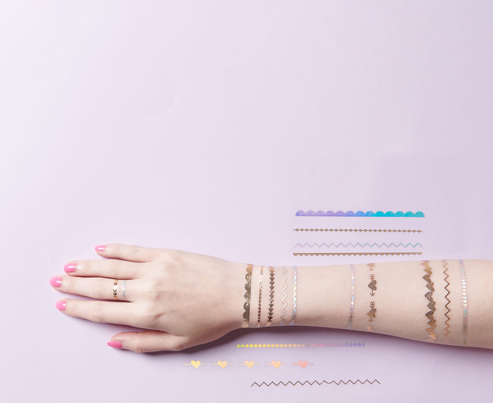 Arm ist mit temporären Tattoos beklebt mit stylishen Motiven im Festival-Look. 