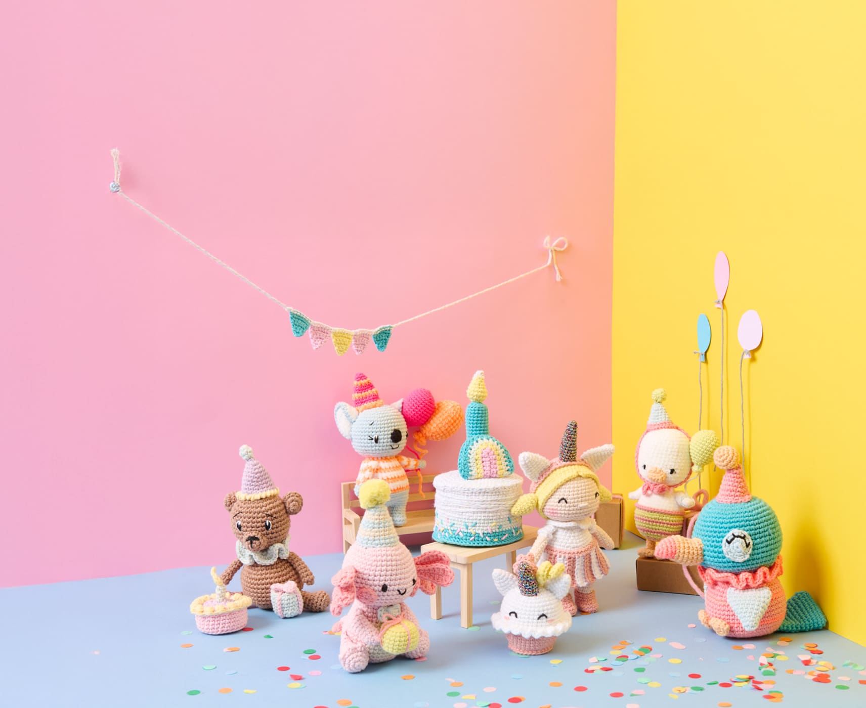 Sieben Amigurumis zum Thema Birthday Party sind mit Partyaccessoires vor bunten Wänden dekoriert. 