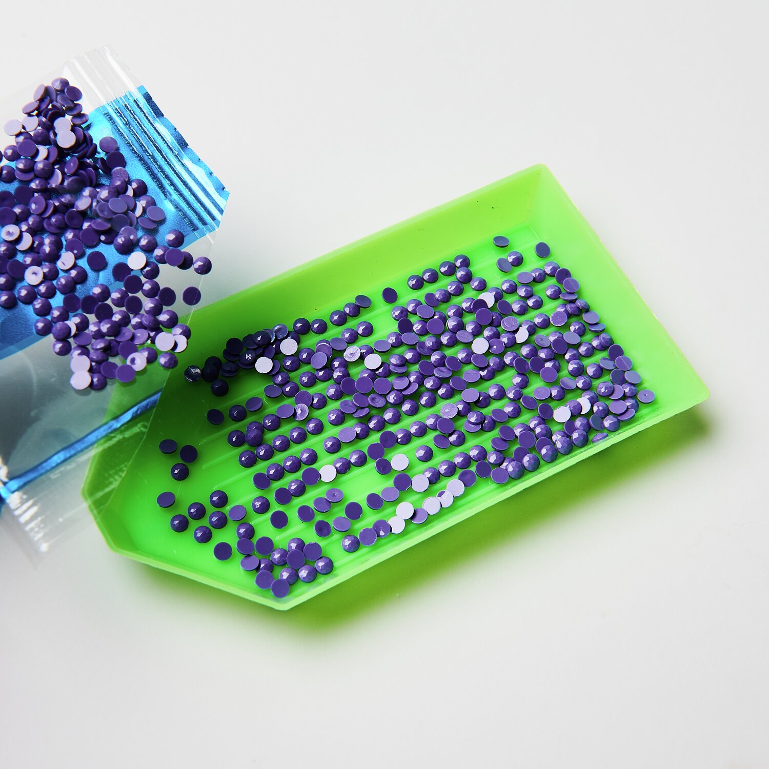 Diamond Painting Masken Tiere, 52-teilig: Lila Strasssteine auf grünem Tablett, ideal für kreative Bastelprojekte.