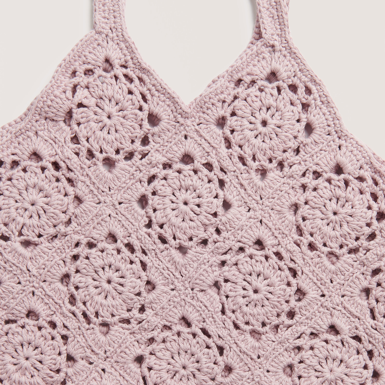 Die Neue Masche No. 12 Frühjahr-Sommer zeigt ein gehäkeltes Top in Mauve mit kreisförmigen Mustern.