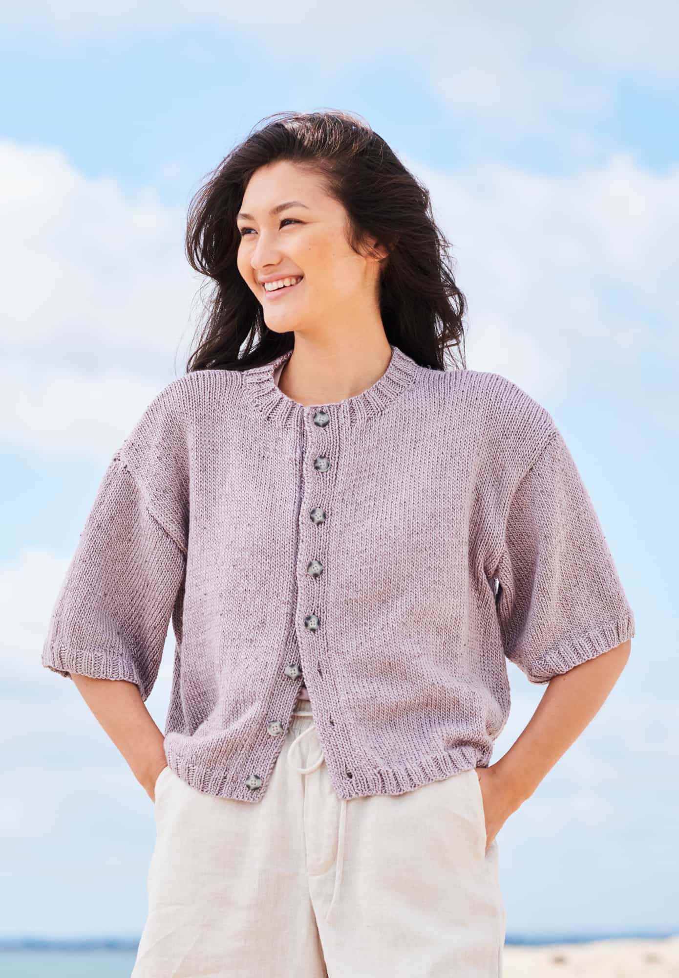 Frau trägt gestrickte Kurzarm Jacke in Flieder: Modell 11 aus Lovewool No. 22