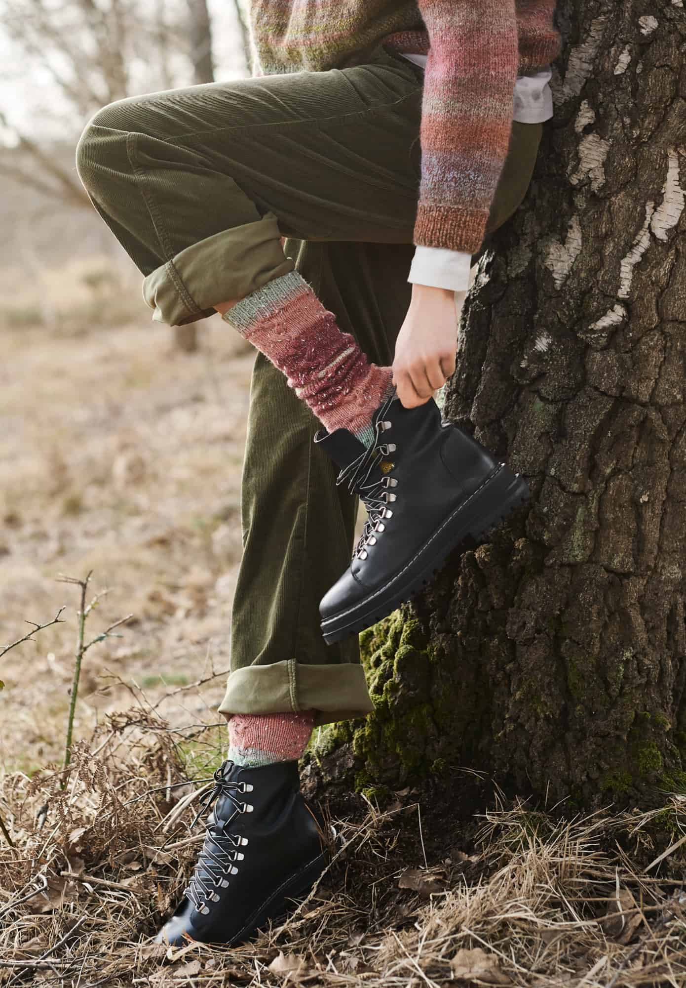 Frau trägt gestrickte Socken in Rot- und Naturtönen: Modell 08 aus Lovewool No. 21