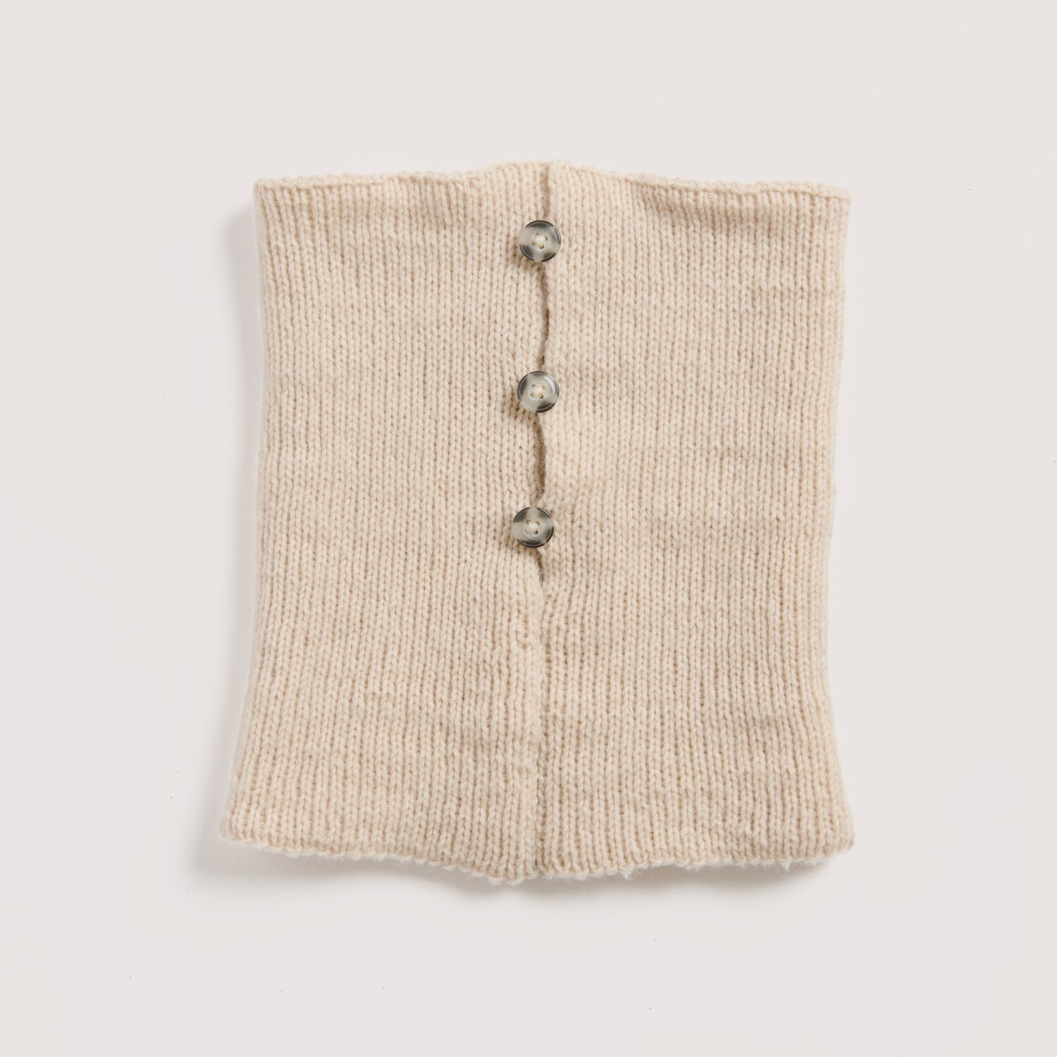Strickset Kragen Modell 03 aus Luxury Knits Little Pieces, gestrickter Halswärmer mit mittiger Knopfleiste und drei dekorativen Knöpfen auf hellem Untergrund