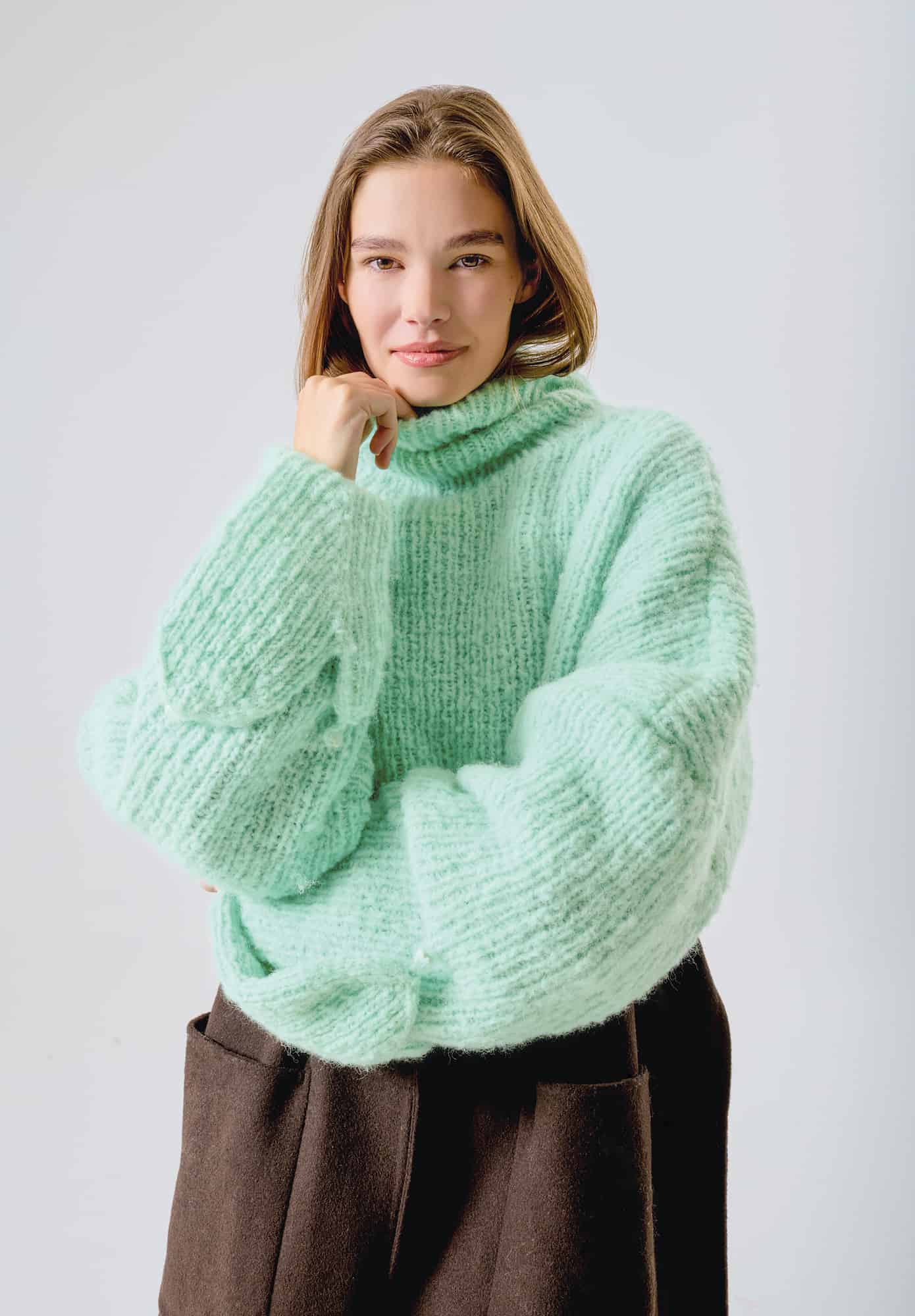 Frau trägt gestrickten Pullover mit Kapuze und Handschuhen in Mint: Modell 15 aus Made by Me No. 21