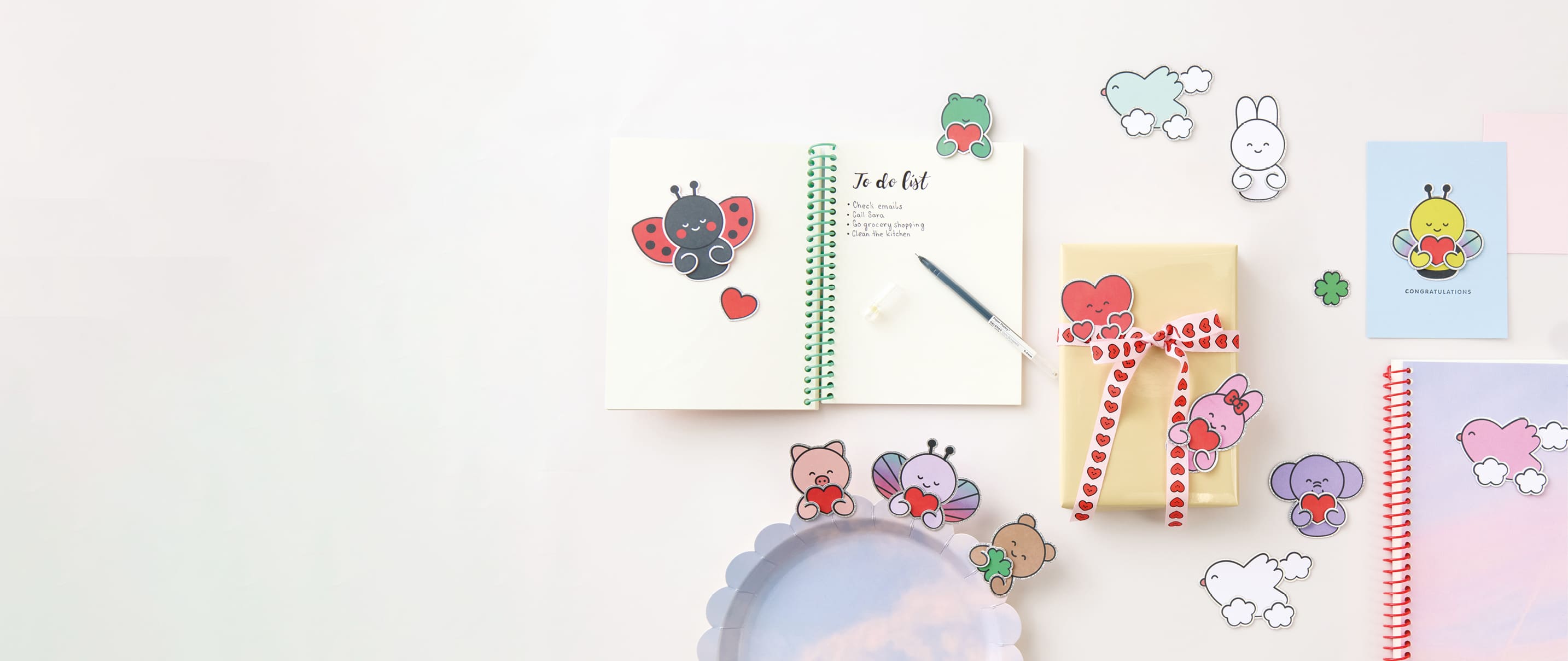 Clip-Ons in Form von illustrierten Tieren sind dekorativ an Notizbüchern, Geschenken und Karten angebracht.  