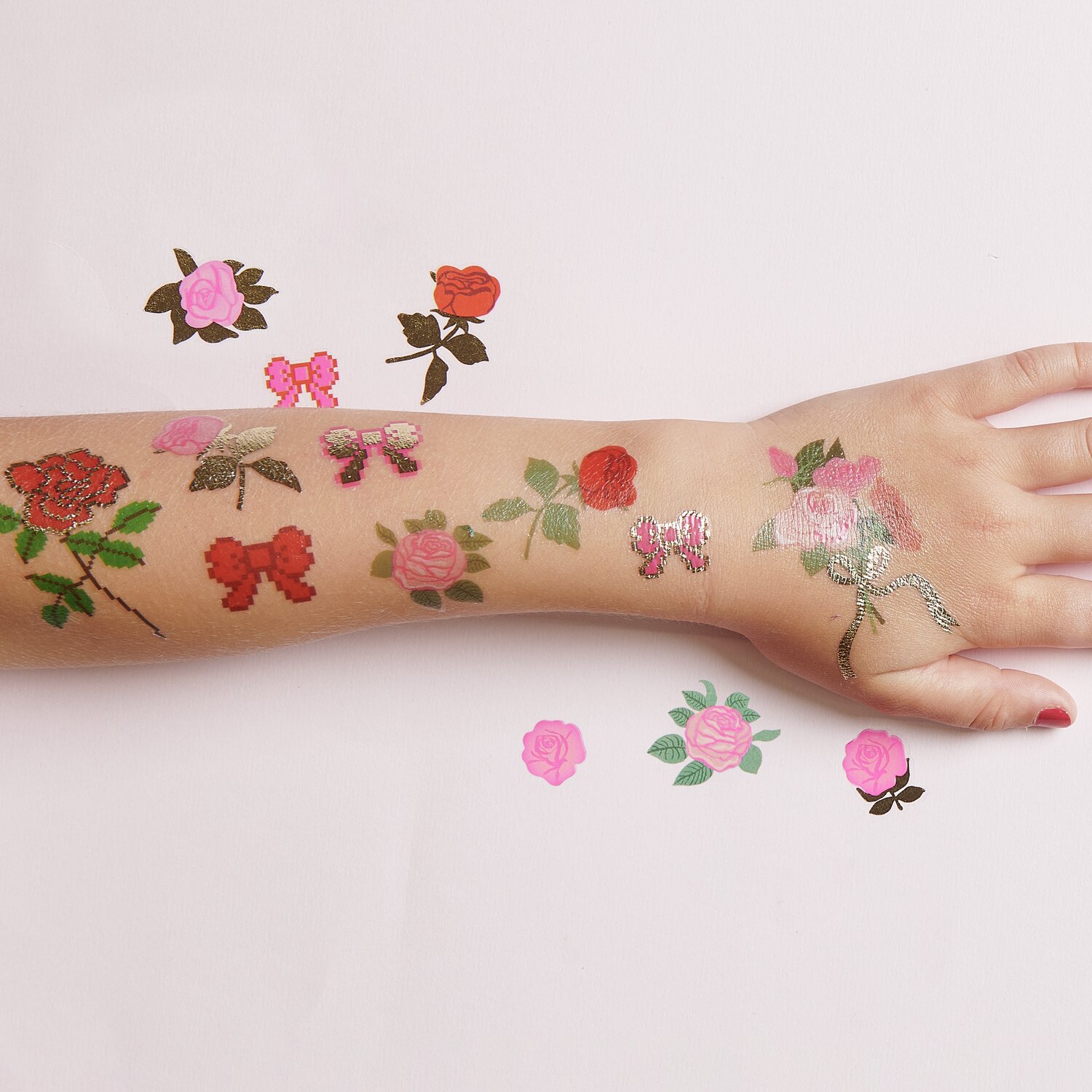 Tattoos Pixel Rosen: Temporäre Tattoos mit Rosen- und Schmetterlingsmotiven auf einem Arm. 15-teiliges Set.