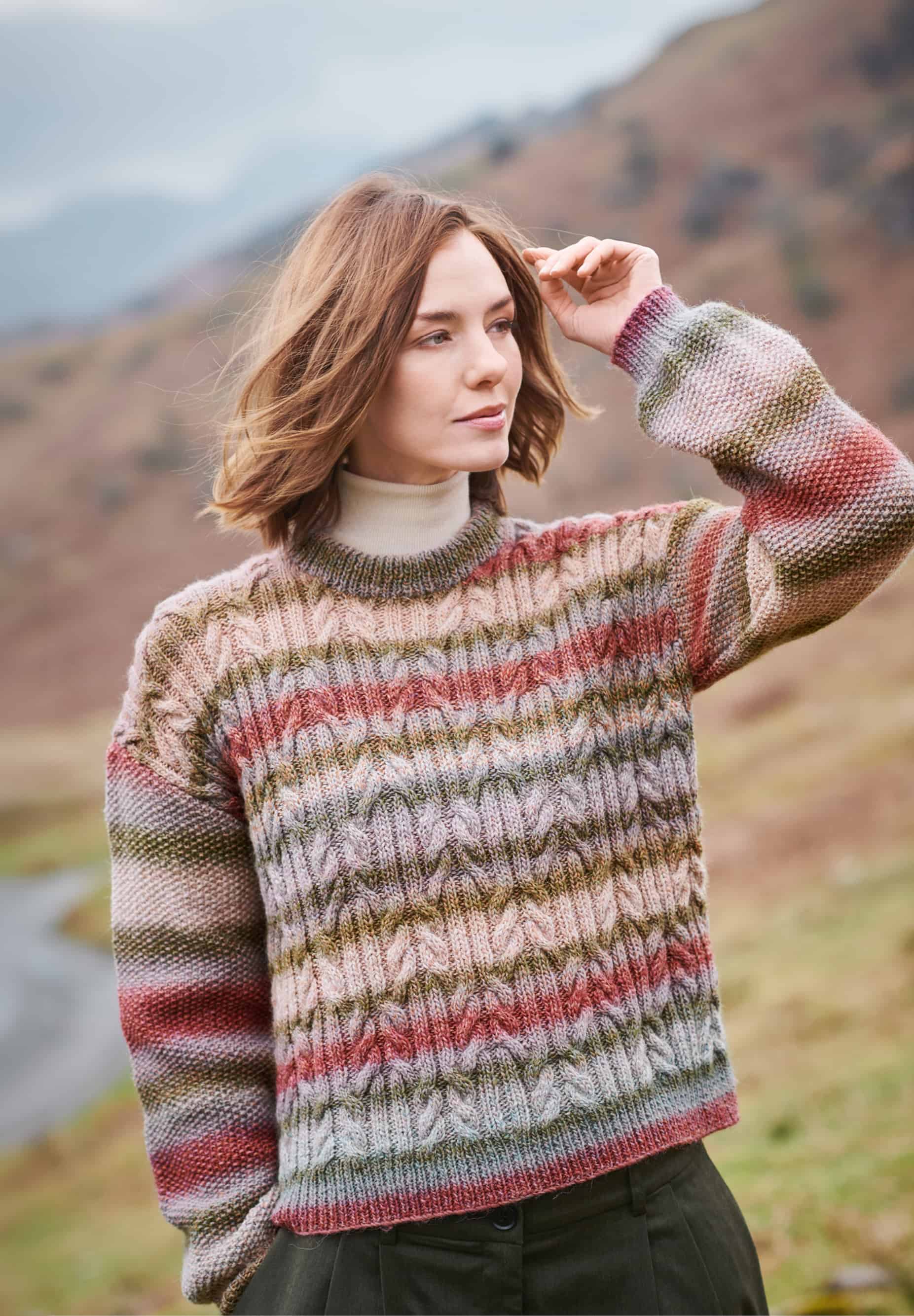 Frau trägt gestrickten Pullover mit Zopfmuster und Farbverläufen in Naturtönen: Modell 39 aus Lovewool No. 23