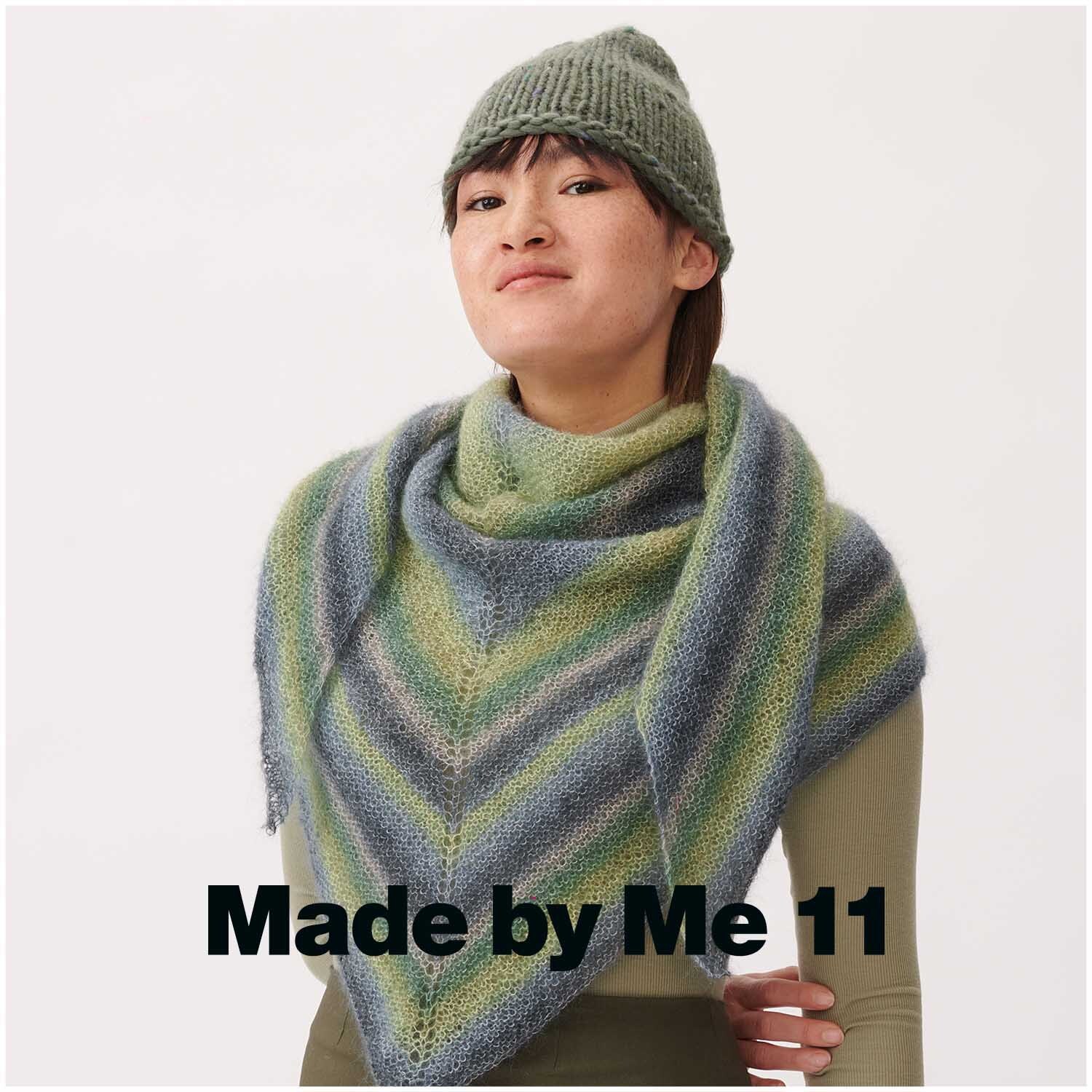 Essentials Super Kid Mohair Loves Silk Print: Frau trägt gestricktes Dreieckstuch in Grüntönen von Rico Design.