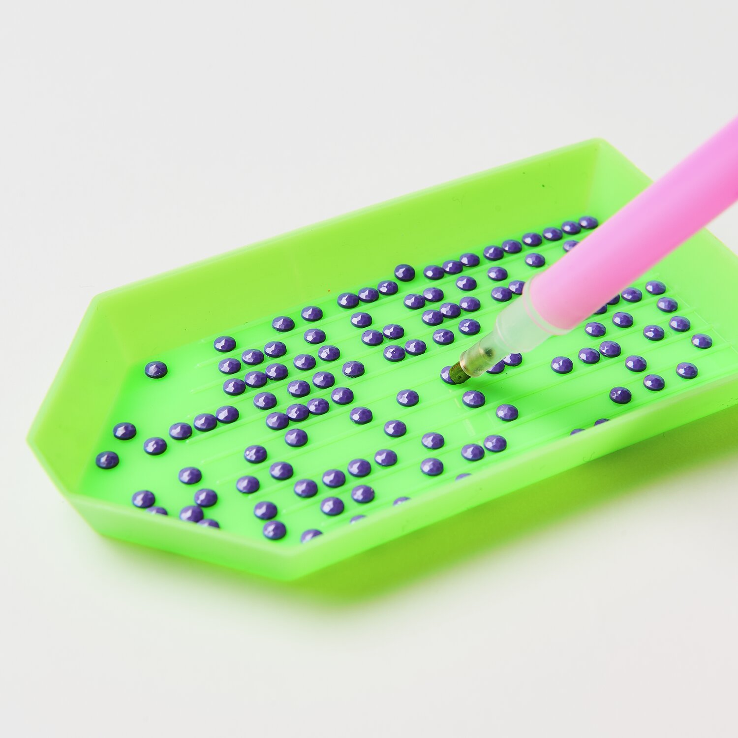 Diamond Painting DIY-Set Frühlingswiese: Grünes Tablett mit lila Steinen und pinkem Stift.