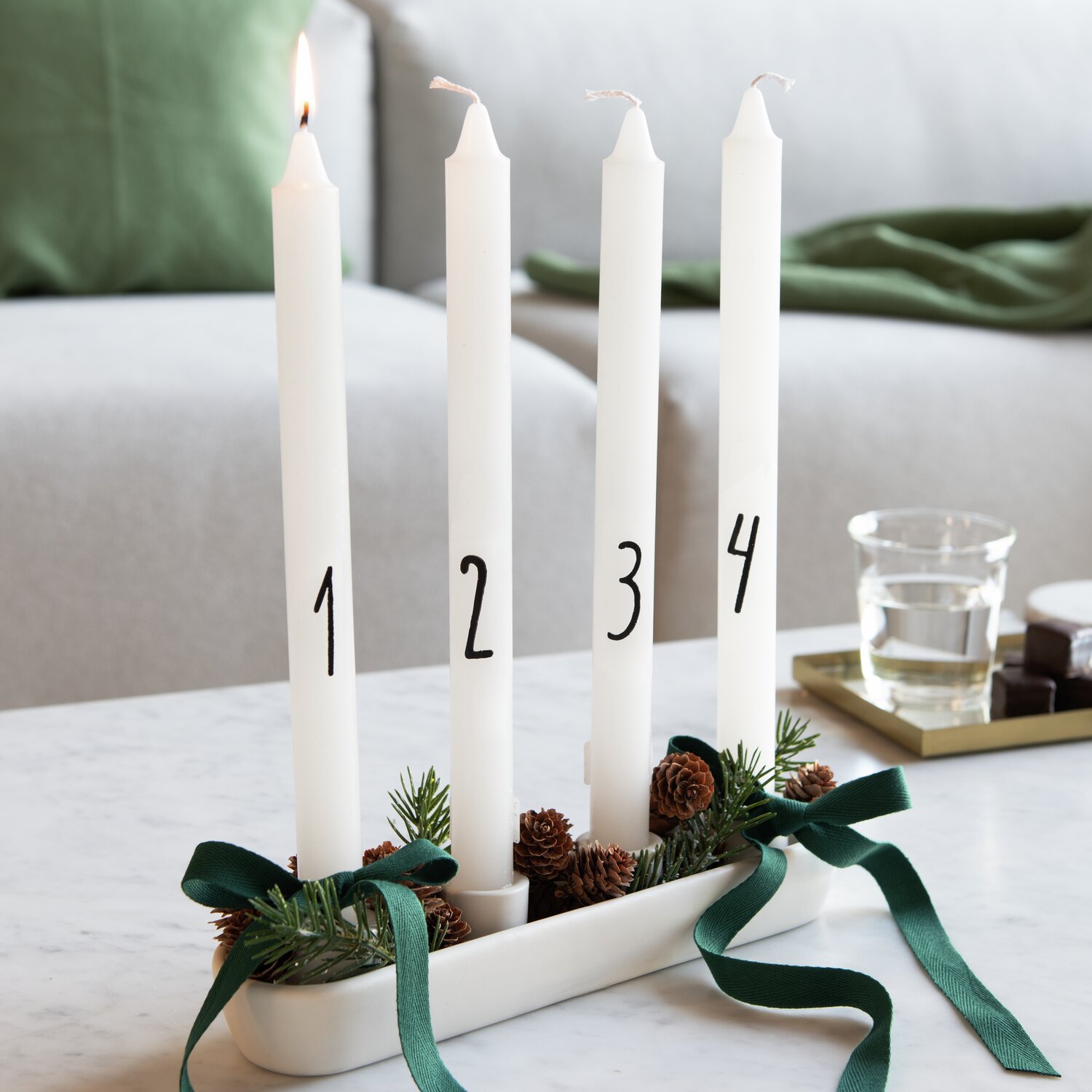 Adventskerzenset 4 Stück, Ø2,2x28cm, dekoriert mit Tannenzweigen und grünen Schleifen.