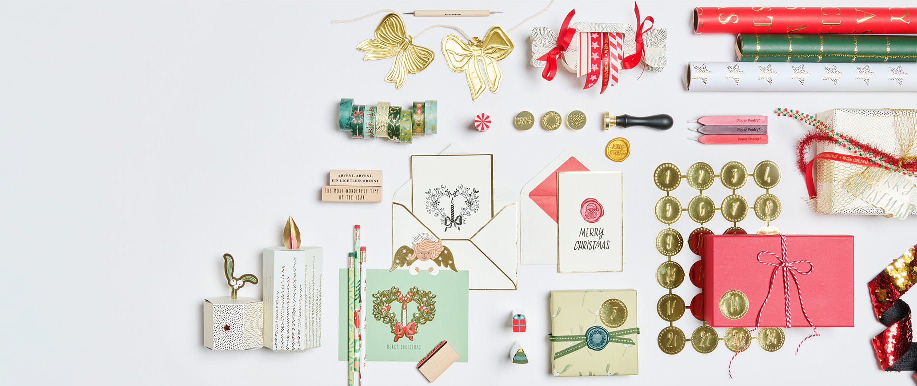 Papeterie- und Geschenkprodukte aus der Weihnachtskollektion "Advent, Advent" liegen angeordnet auf grauem Hintergrund.