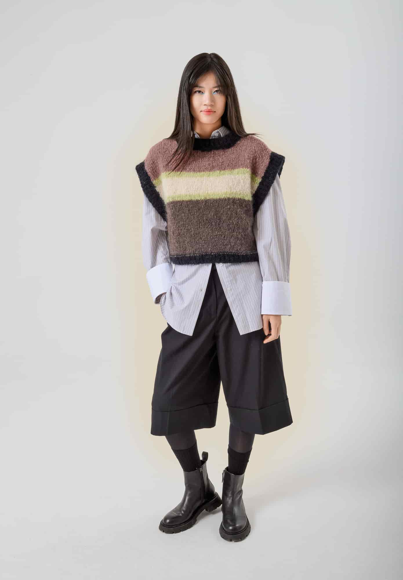 Frau trägt gestrickten Pullunder mit Streifen in Schwarz, Natur, Taupe, Mauve und Pistazie: Modell 34 aus Made by Me No. 21