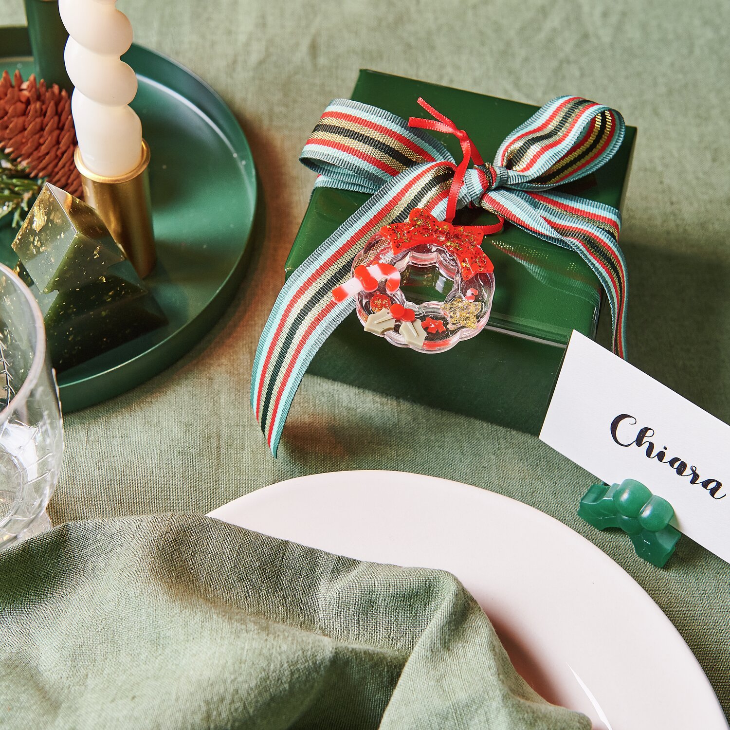 Silikon Gießform Mini-Weihnachtskranz 1 Stück von Rico Design Silikon Gießform Mini-Weihnachtskranz auf grünem Geschenk mit rot-grünem Band dekoriert.