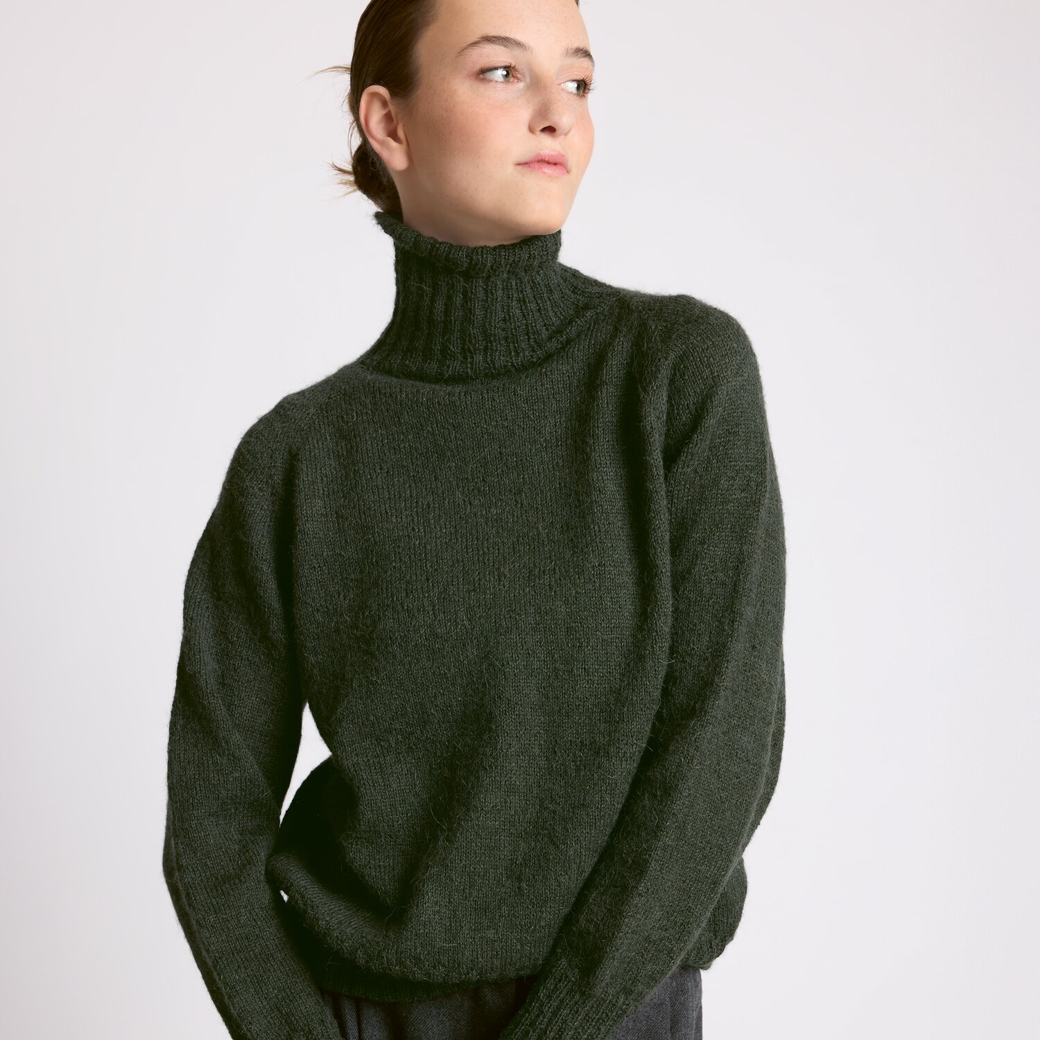 Strickset Pullover Modell 15 aus Luxury Knits - Premium Natural Fibres von Rico Design Strickset Pullover Modell 15 aus Luxury Knits: Dunkelgrauer Rollkragenpullover aus Premium Natural Fibres, getragen von einer Person.