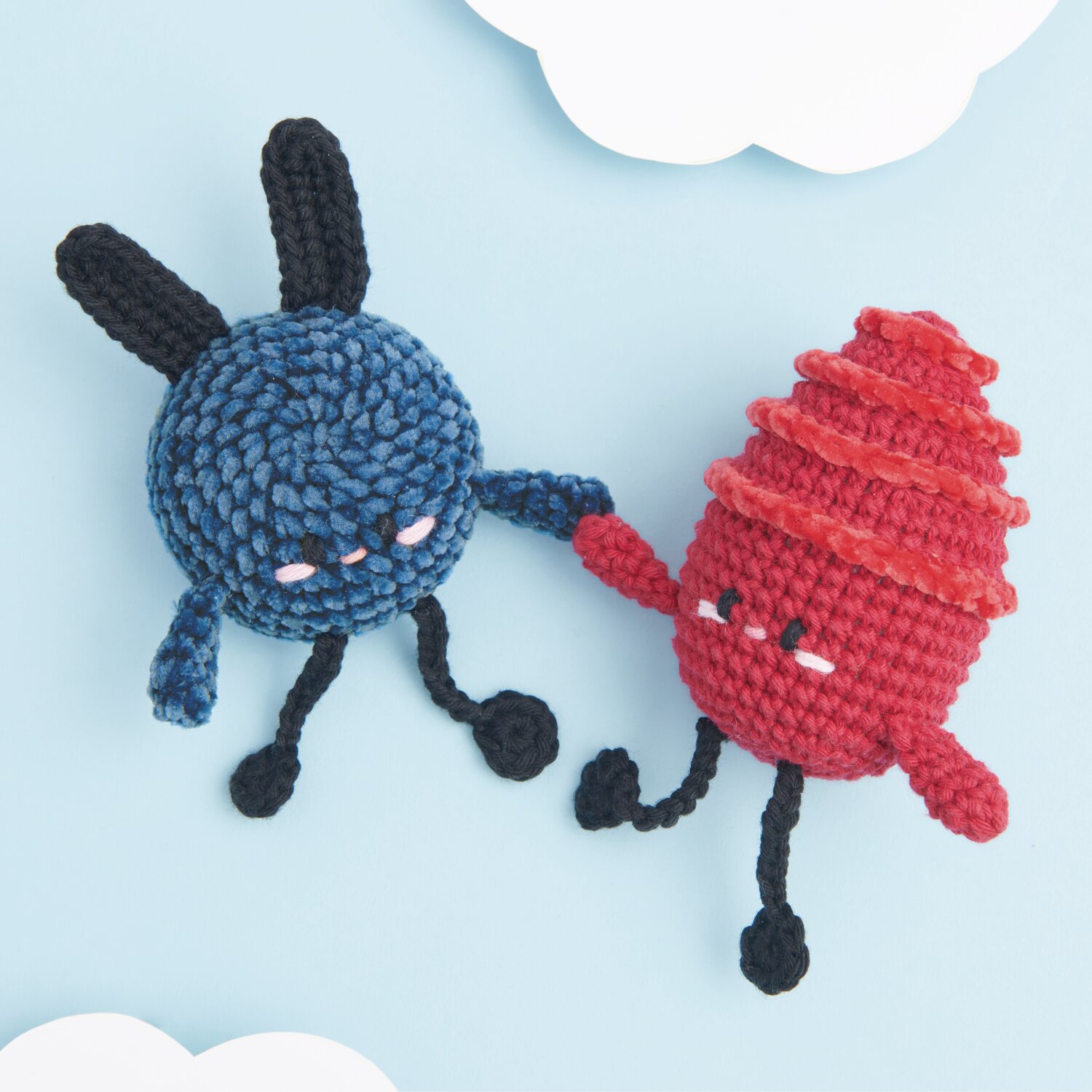 Ricorumi Nilli Nilli: Zwei gehäkelte Figuren in Blau und Rot von Rico Design, die sich an den Händen halten.