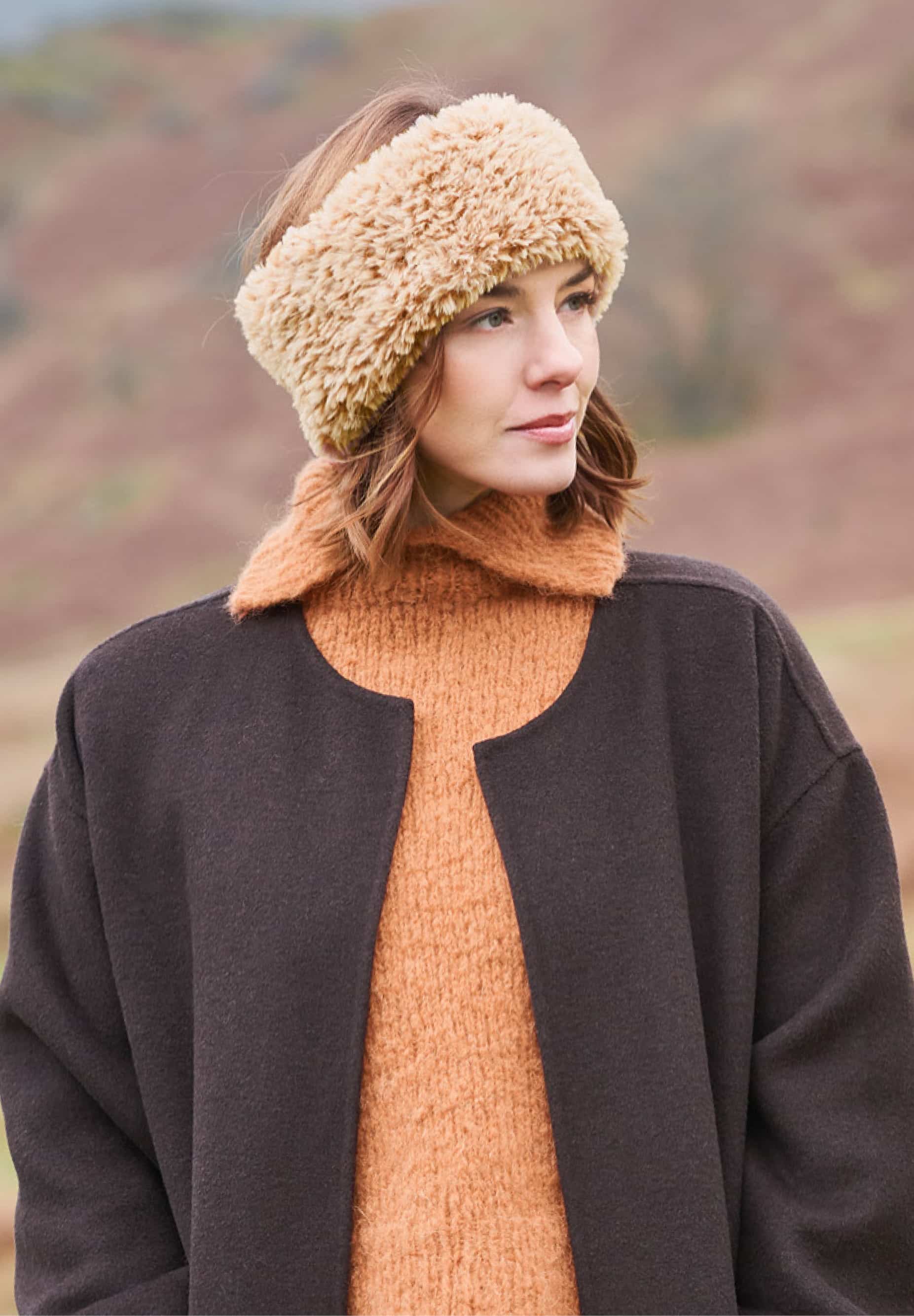 Frau trägt gestricktes, hellbraunes Stirnband in Felloptik: Modell 26 aus Lovewool No. 23