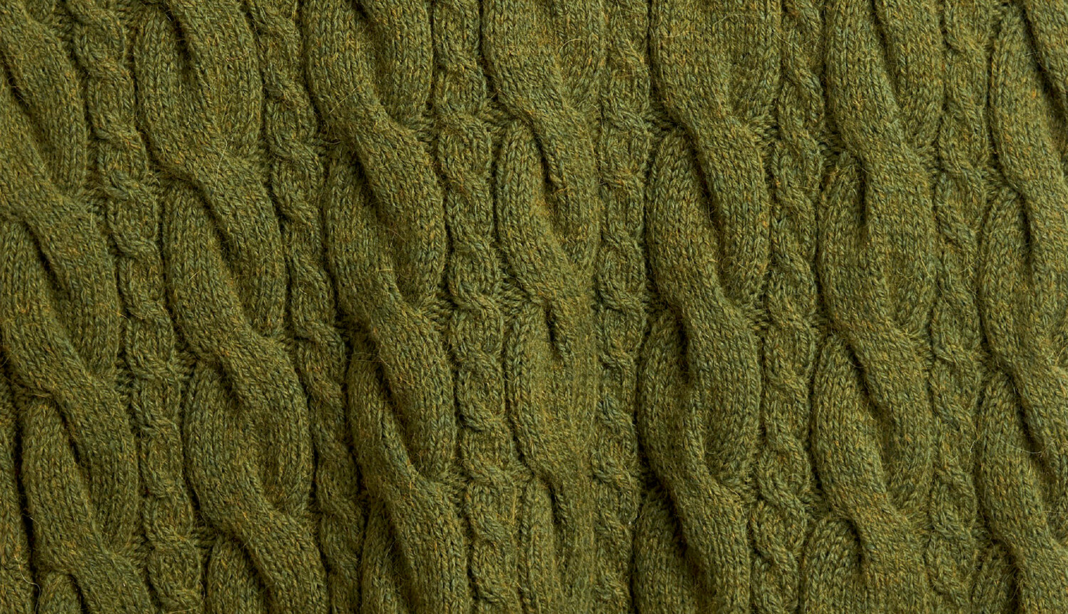 Strickanleitung Pullunder aus Soft Alpaca, detailreiche Nahaufnahme mit plastischem Zopfmuster in melierter Olivnuance, weiche Struktur für warme Handarbeit