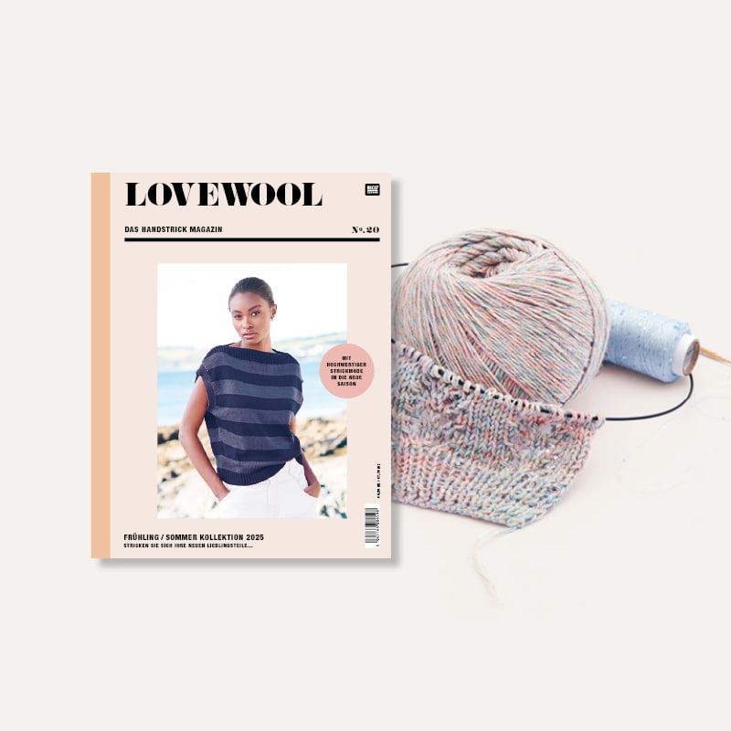 Strickheft Lovewool Nr. 20 neben Wollknäuel und Strickstück auf Strickrundnadel