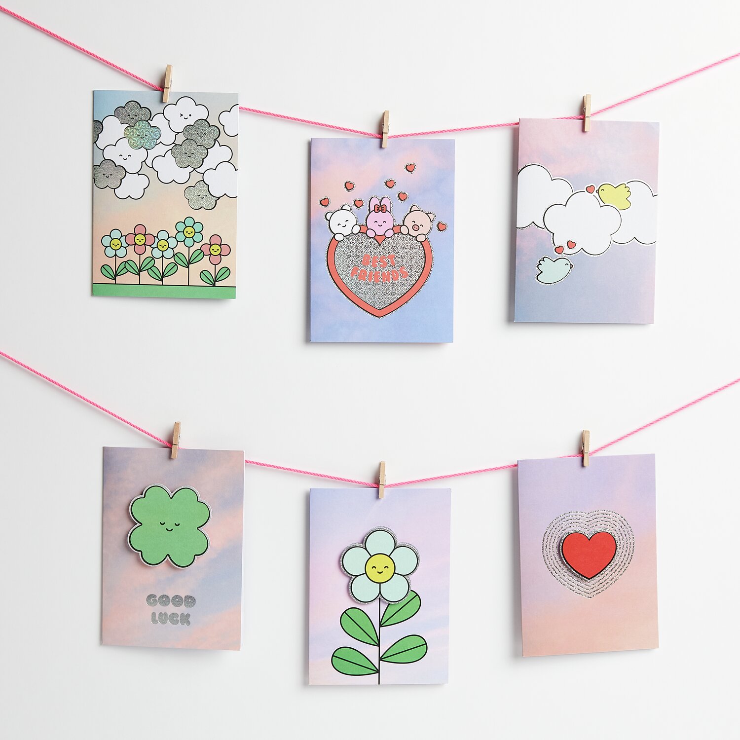 Paper Poetry 3D-Kartenset Chingu mit bunten Motiven, aufgehängt an rosa Schnur, Format B6.