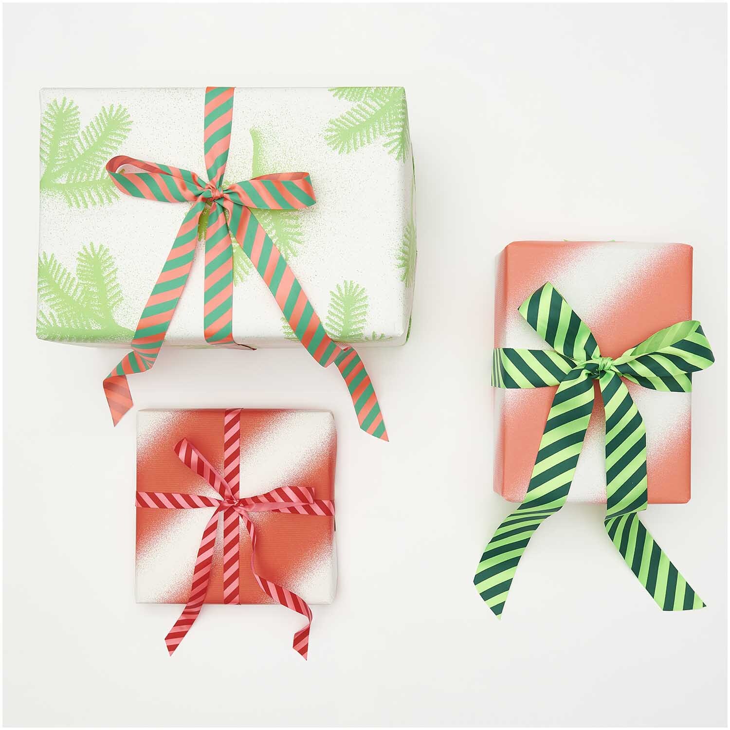 Paper Poetry Satinband Streifen 25mm 3m: Drei Geschenke mit bunten Satinbändern in Neon Rot-Türkis dekoriert.