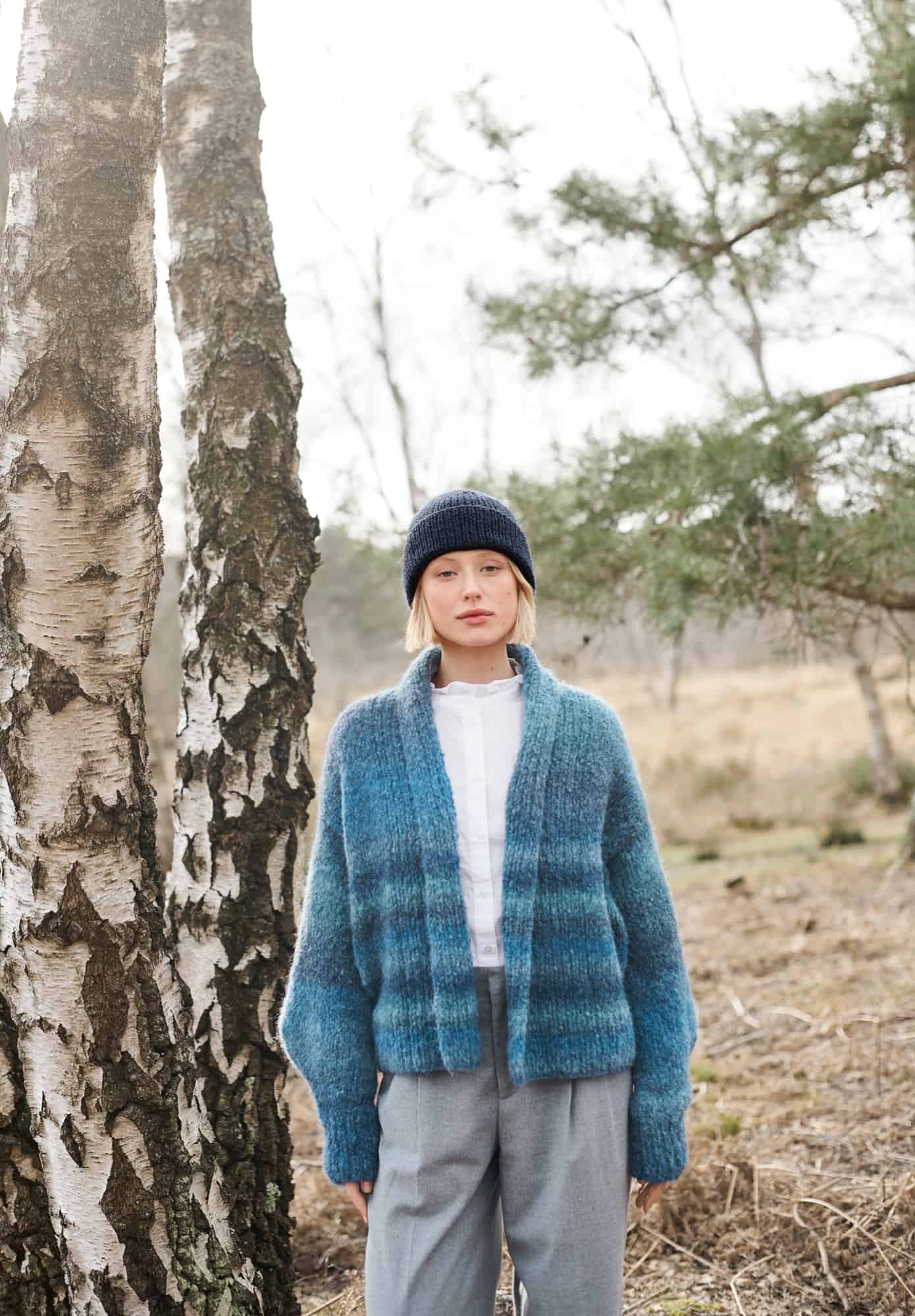 Frau trägt gestrickten Cardigan in Blautönen: Modell 15 aus Lovewool No. 21