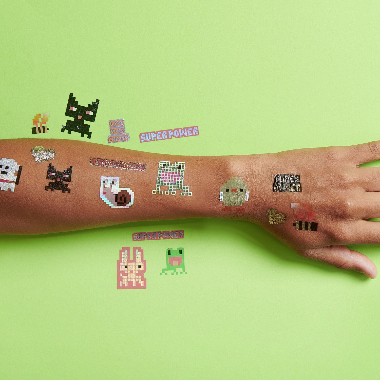 Tattoos Pixel Tiere auf einem Arm mit grünem Hintergrund, 17-teilig, von Rico Design.