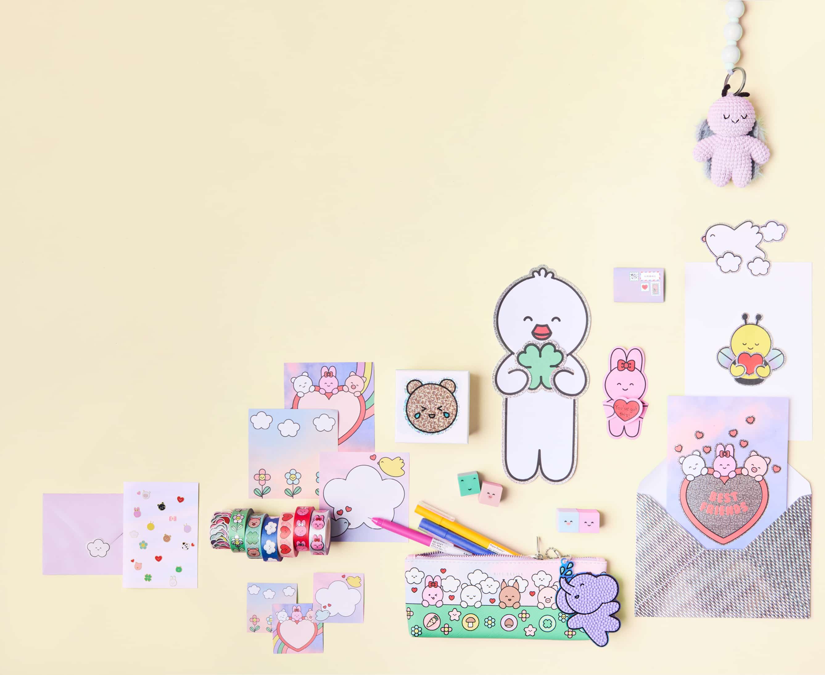 Diverse Papeterie- und Häkelprodukte mit süßen, illustrierten Figuren aus der Kollektion Rico Chingus liegen auf hellem Hintergrund. 