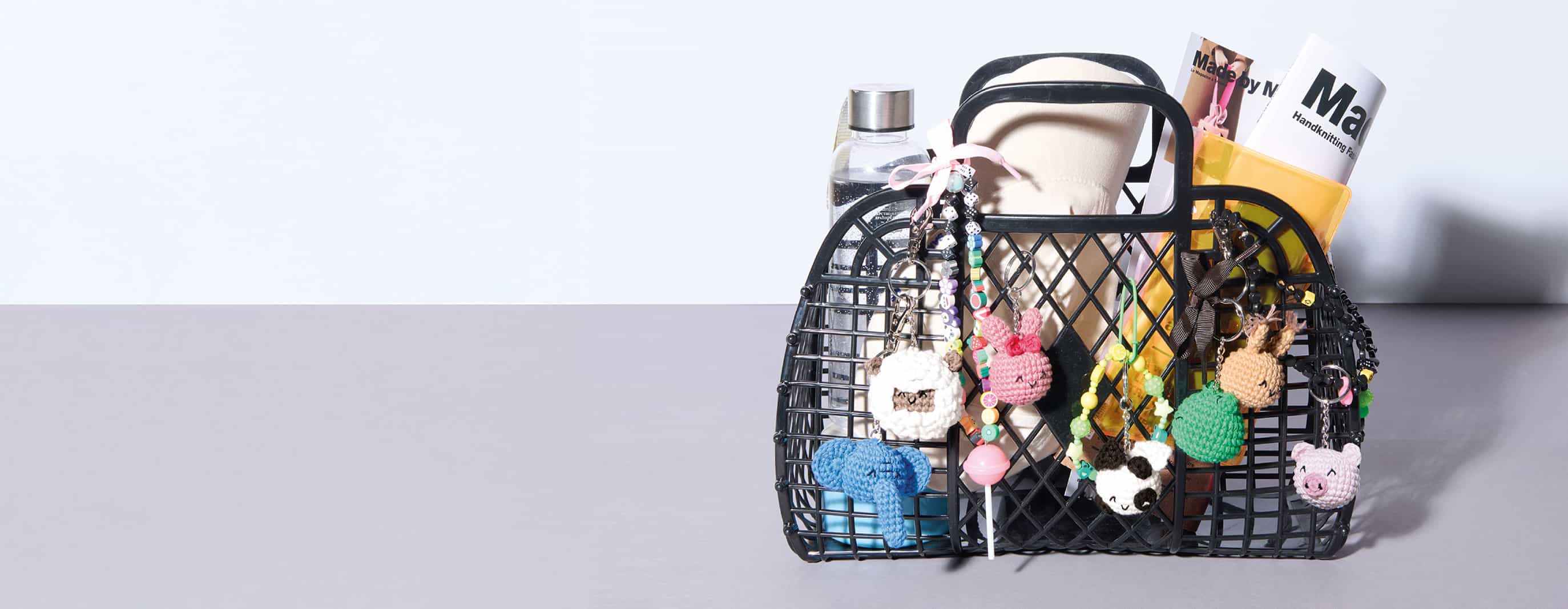 Ein gefüllter Korb ist mit vielen gehäkelten Tier-Anhängern geschmückt.