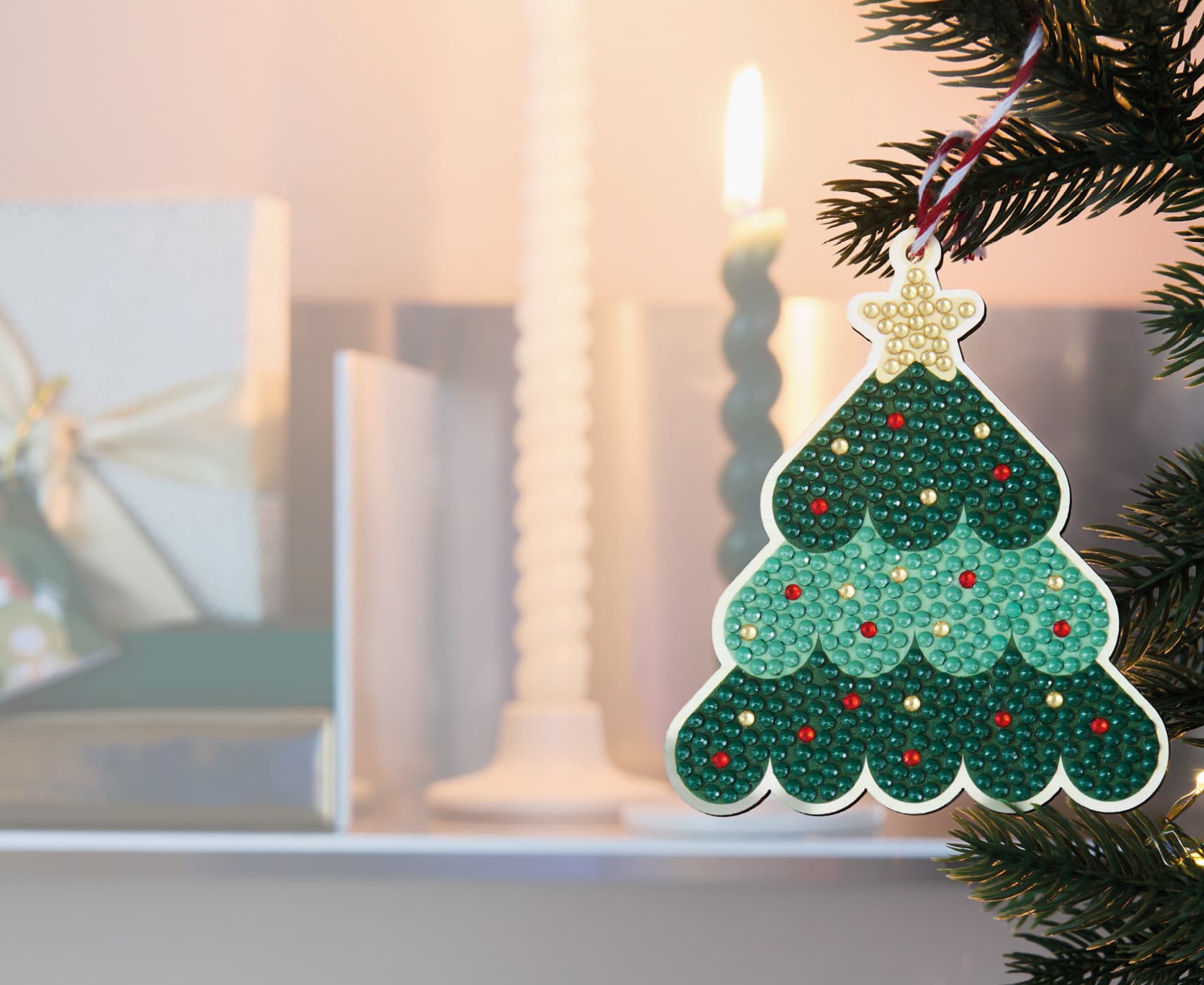 Diamond-Painting-Anhänger in Form eines Weihnachtsbaums als Baumschmuck an einem dekorierten Weihnachtsbaum.