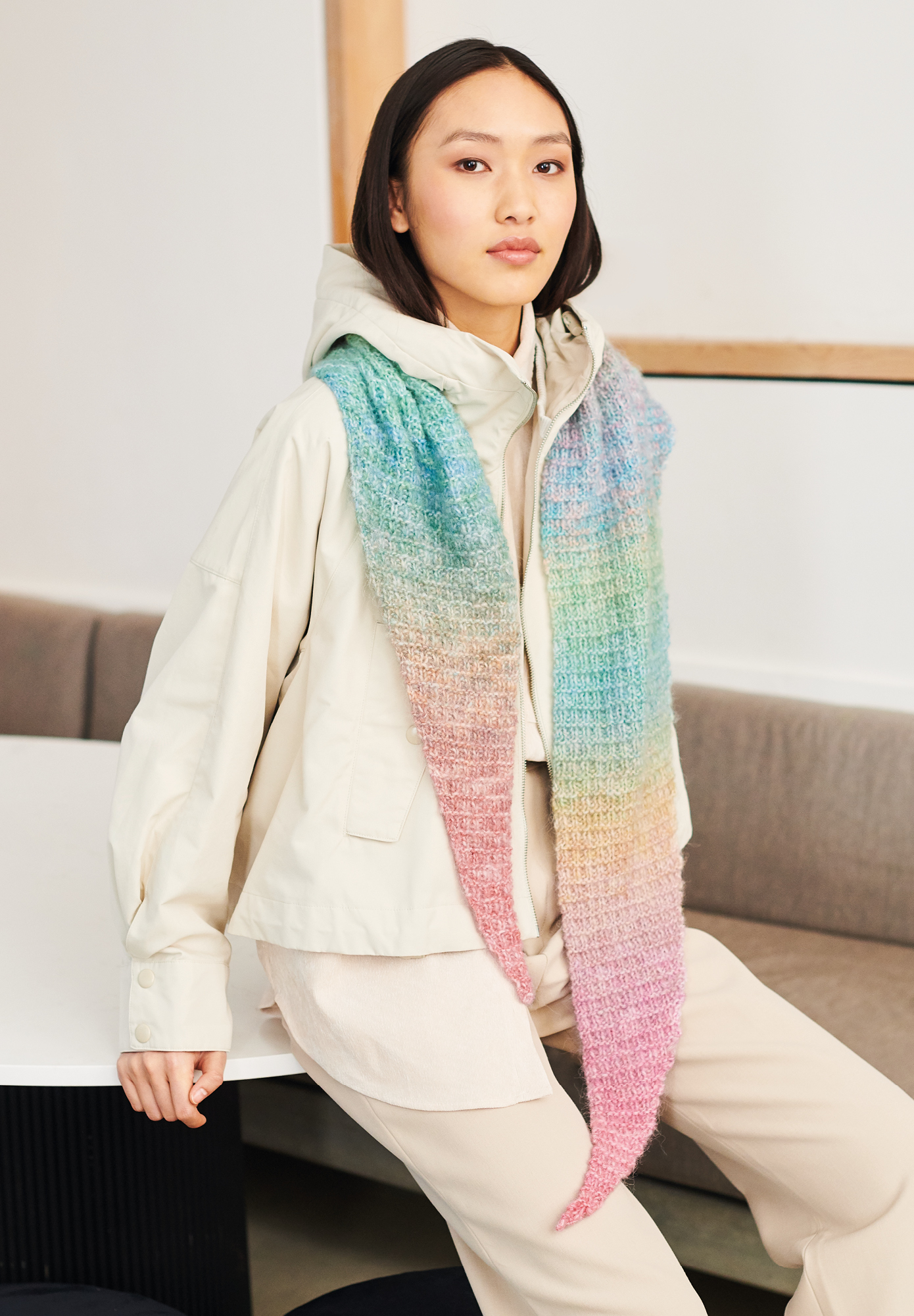 Frau trägt gestricktes Dreieckstuch mit buntem Farbverlauf: Modell 26 aus Lovewool No. 19