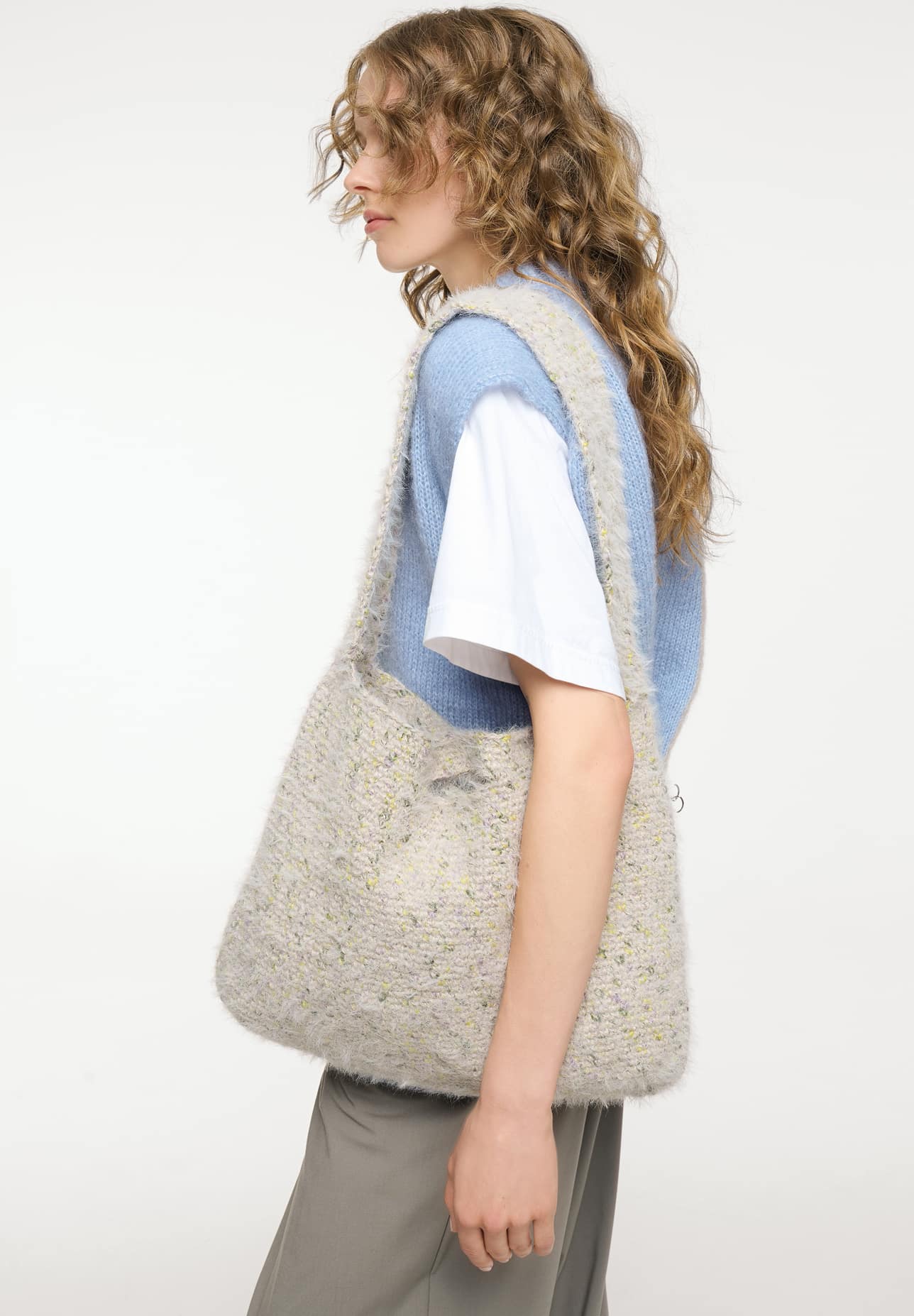 Frau trägt gehäkelte Tasche in Weiß meliert: Modell 11 aus Made by Me No. 22