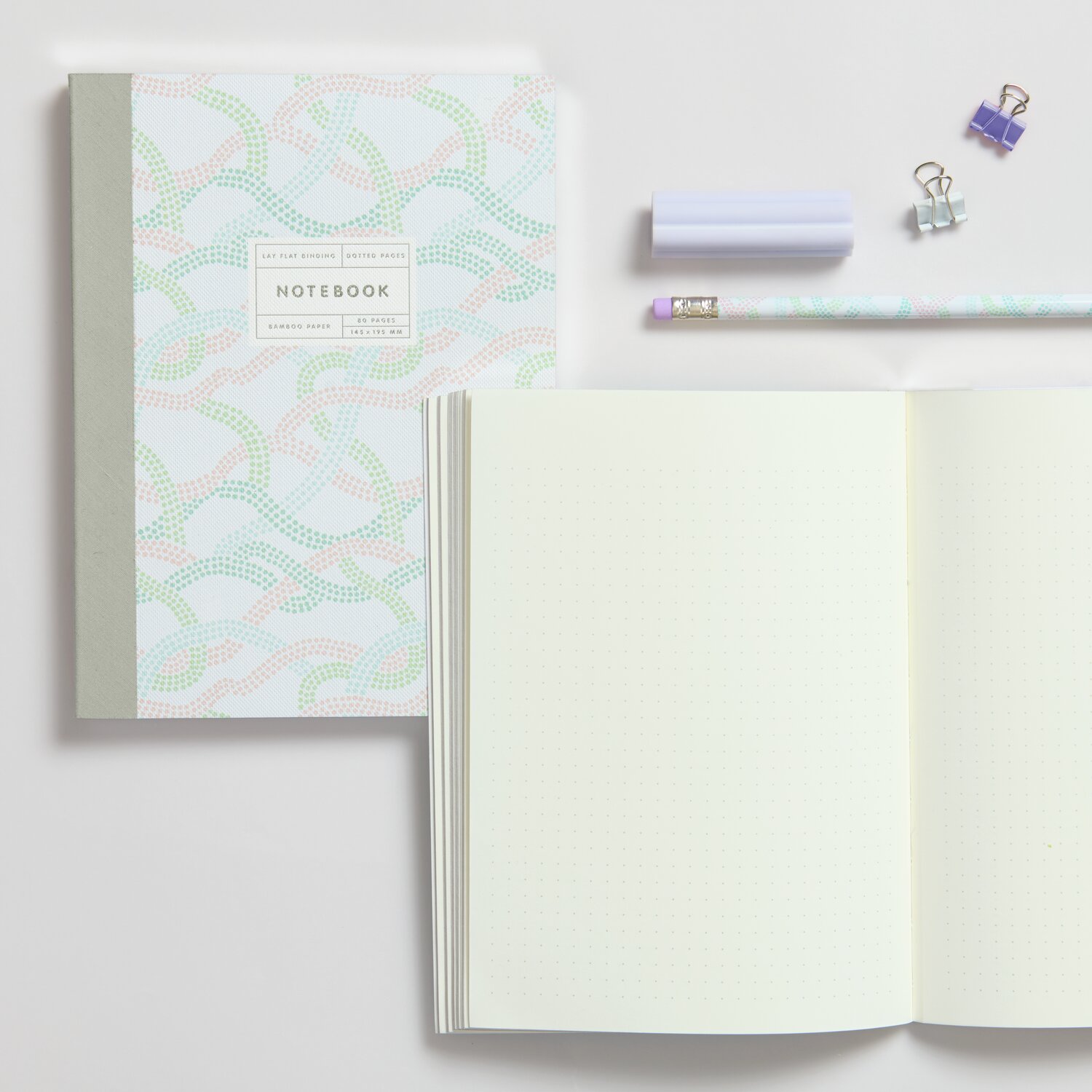 Notizbuch Sky S Waves 80 Blatt mit pastellfarbenem Wellenmuster, offen neben Stift und Clips.