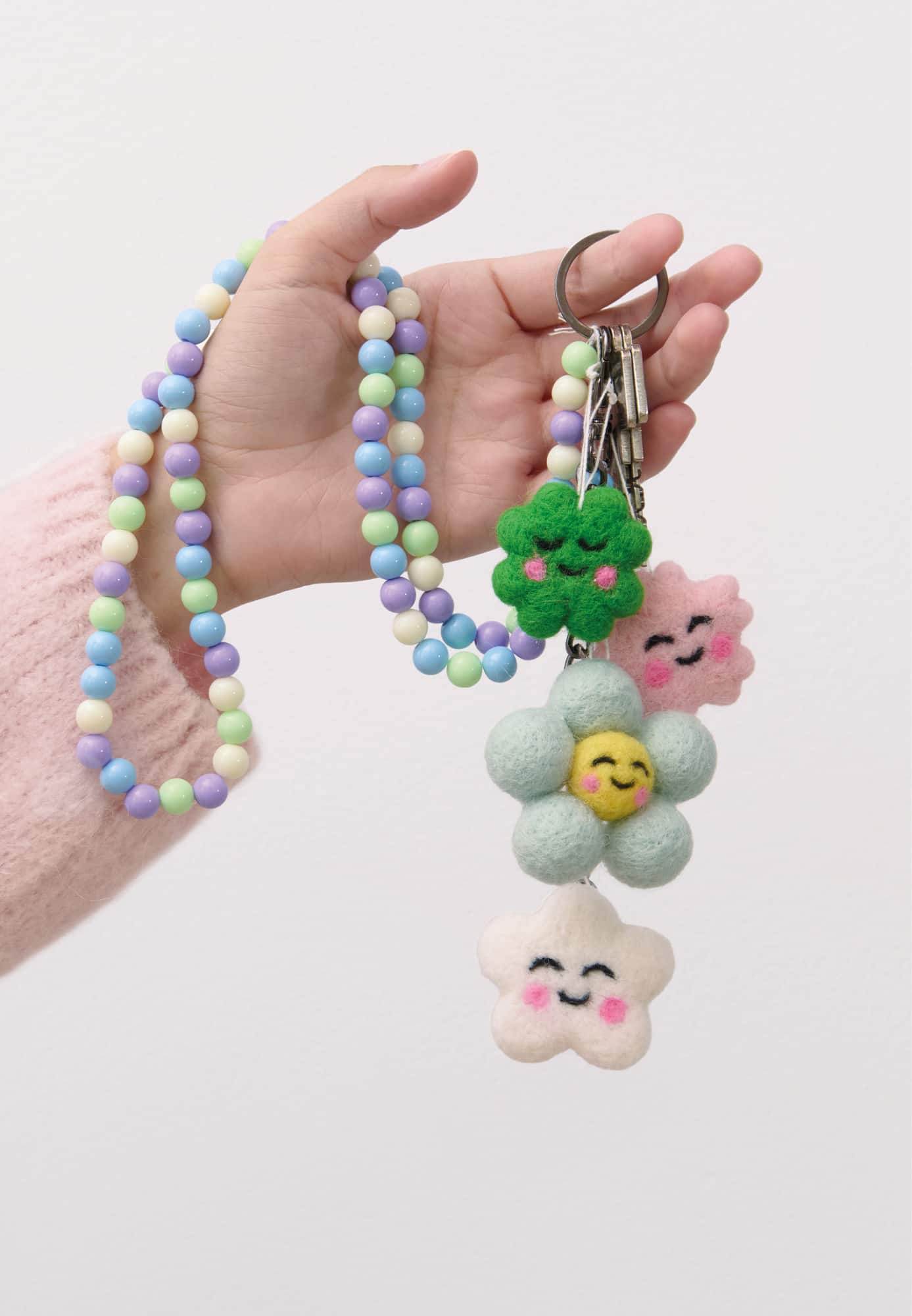 Eine Hand hält Filz-Aufhänger, die an einem Schlüsselbund hängen.