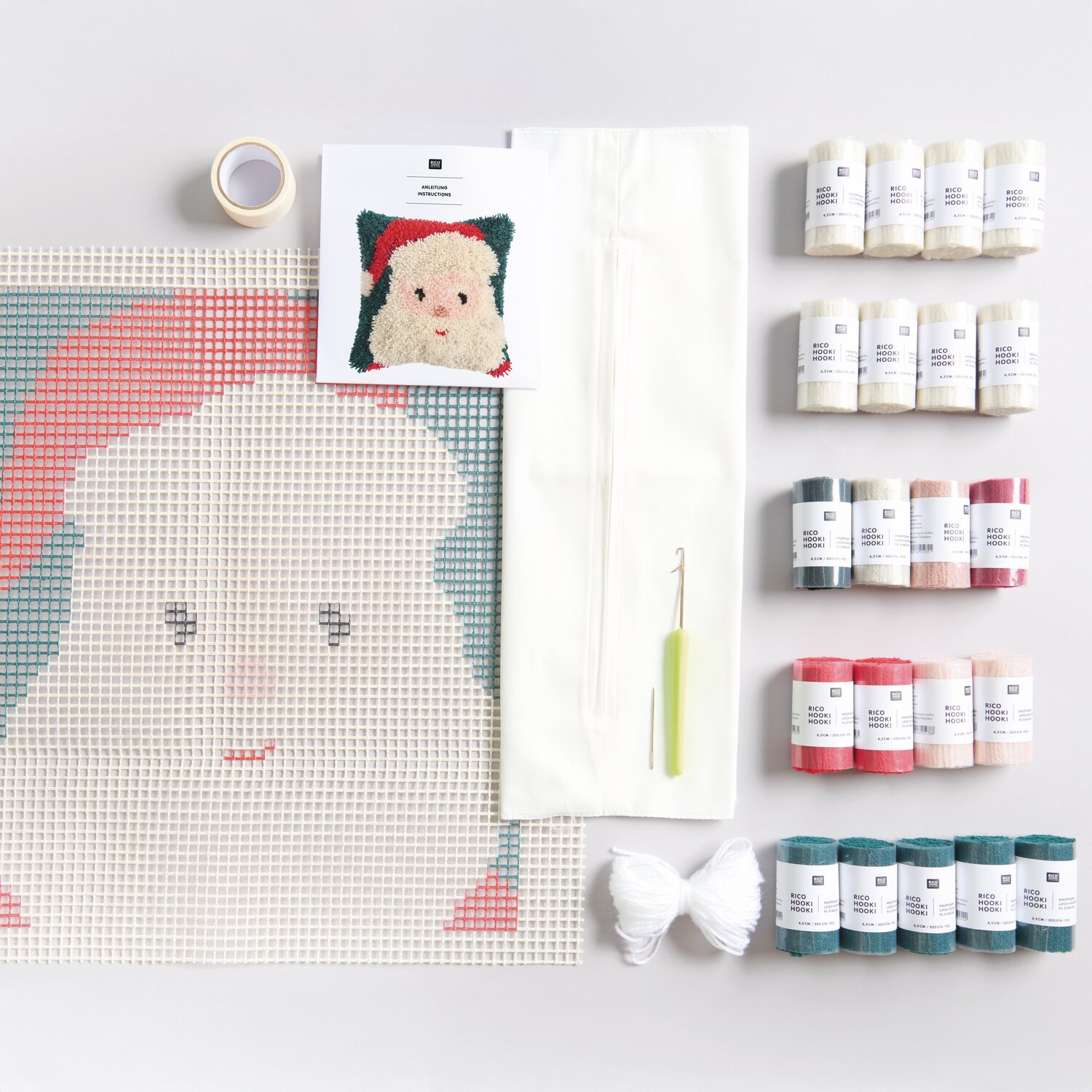 Rico Hooki Hooki Knüpfset Kissen Santa zeigt ein Set mit Garnen, Haken und Anleitung. Ideal für kreative Weihnachtsprojekte in Rot und Weiß.