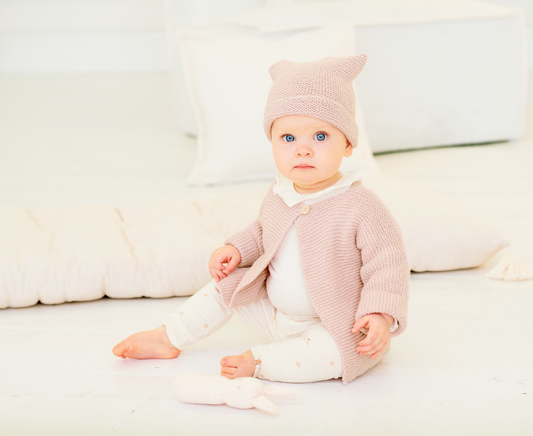 Kleinkind mit gestrickter Jacke und Mütze