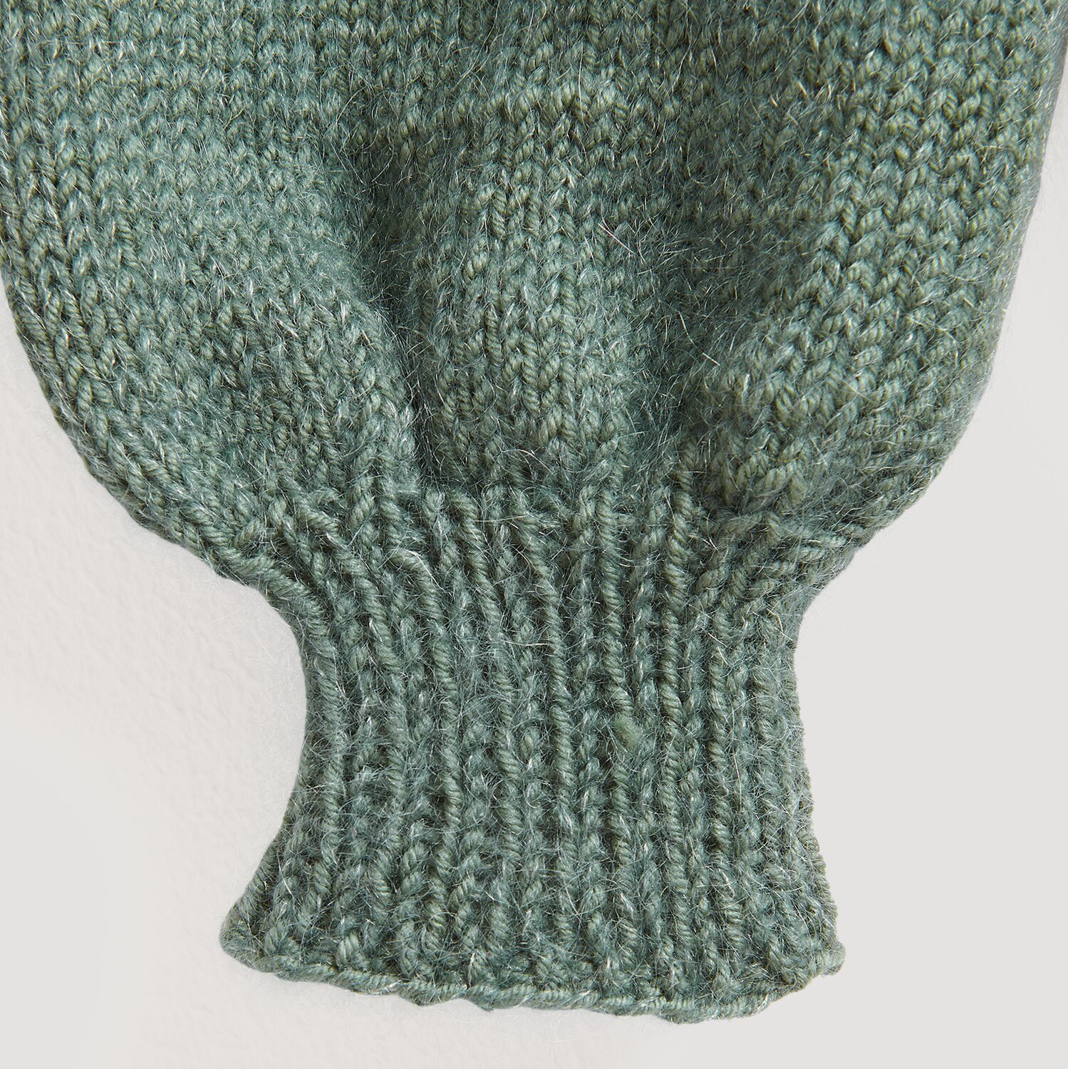 Fashion Meri Mohair Print 50g 275m Farbe Deep Sea von Rico Design Essentials Merino dk: Nahaufnahme eines gestrickten Ärmels in Efeu-Grün, weiche Textur.
