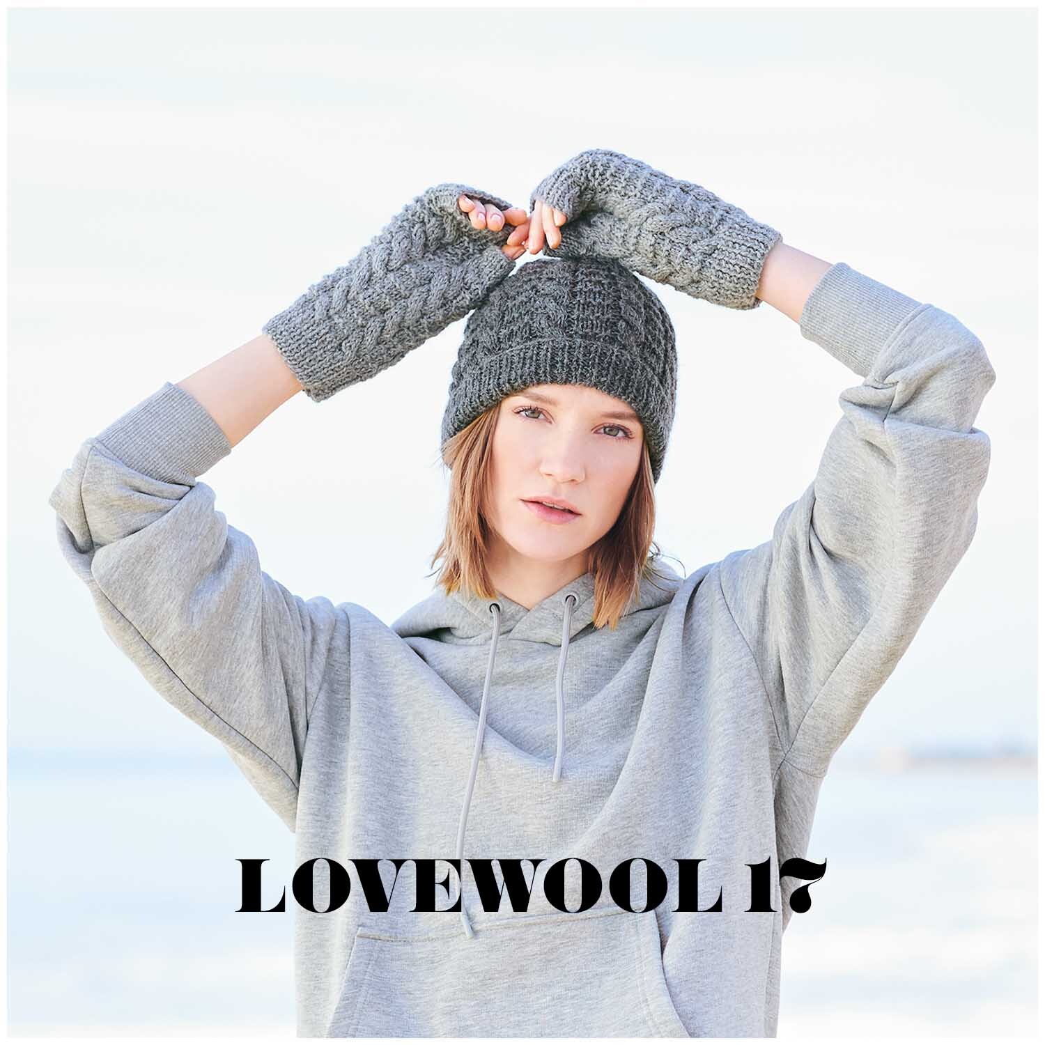 Essentials Baby Alpaca & Merino aran: Frau in grauem Hoodie trägt gestrickte Mütze und Handschuhe. Ideal für kühle Tage.