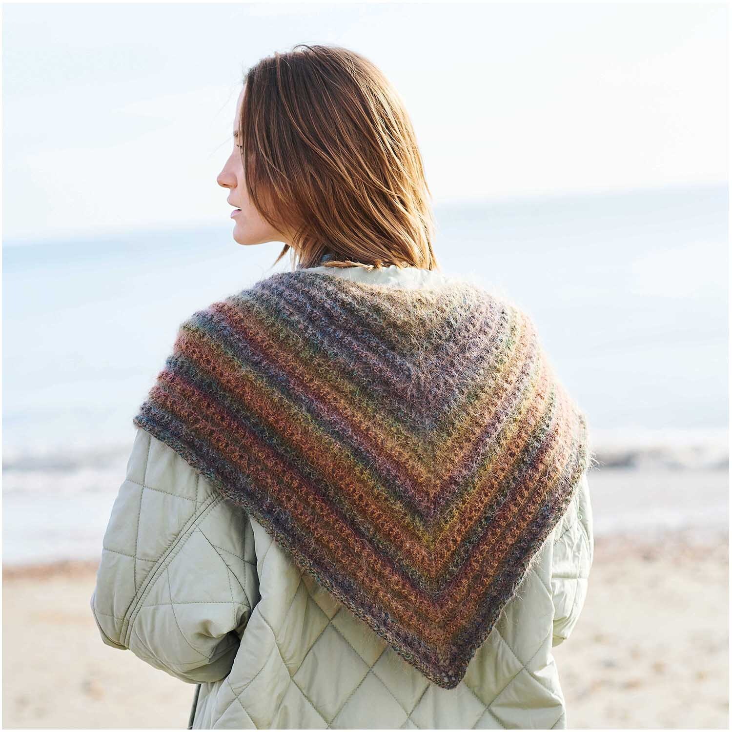 Fashion Mohair Rainbows: Frau am Strand mit einem gestrickten, regenbogenfarbenen Schal von Rico Design.